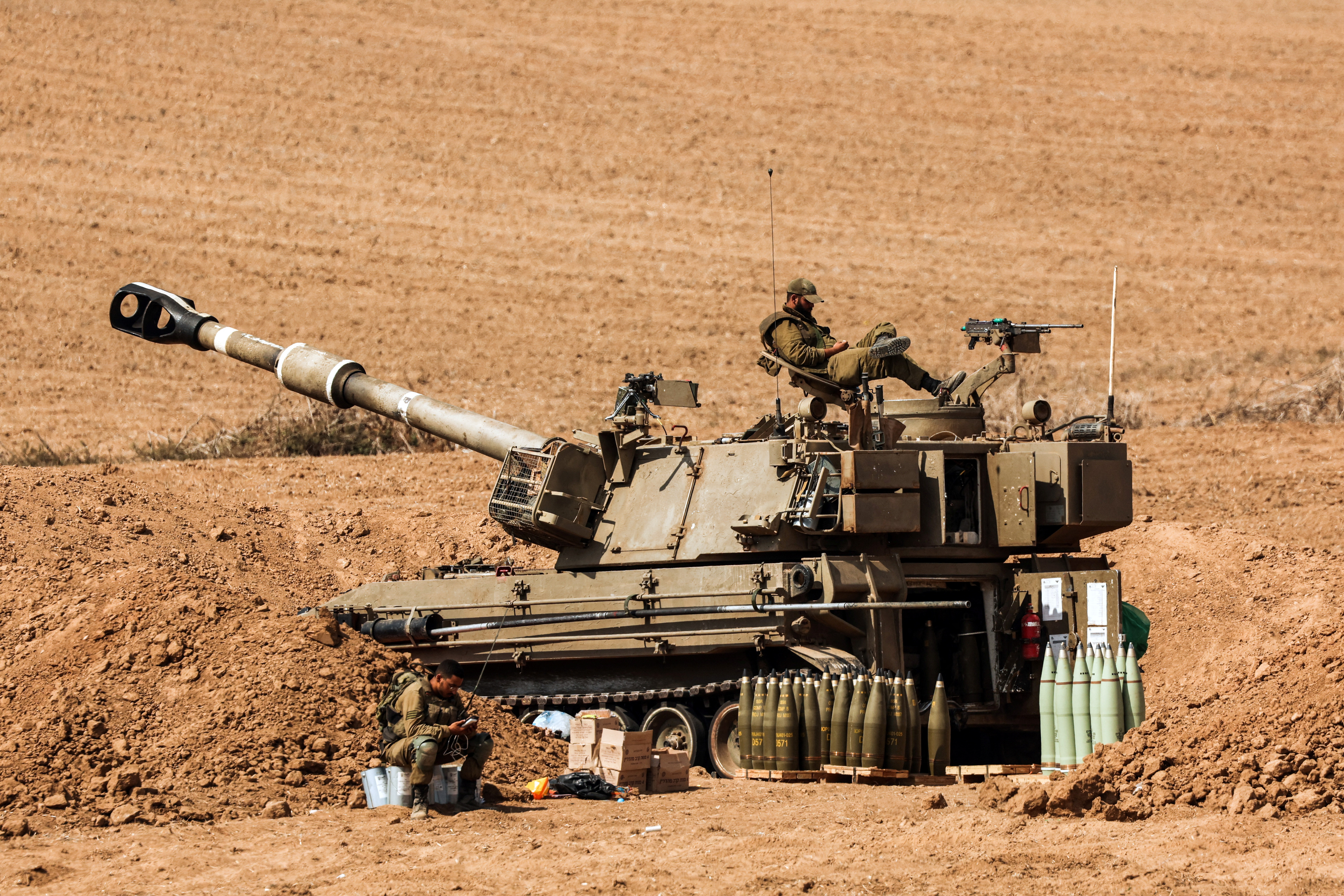 An Israeli soldier sits on a tank near Israel's border with the Gaza Strip, in southern Israel