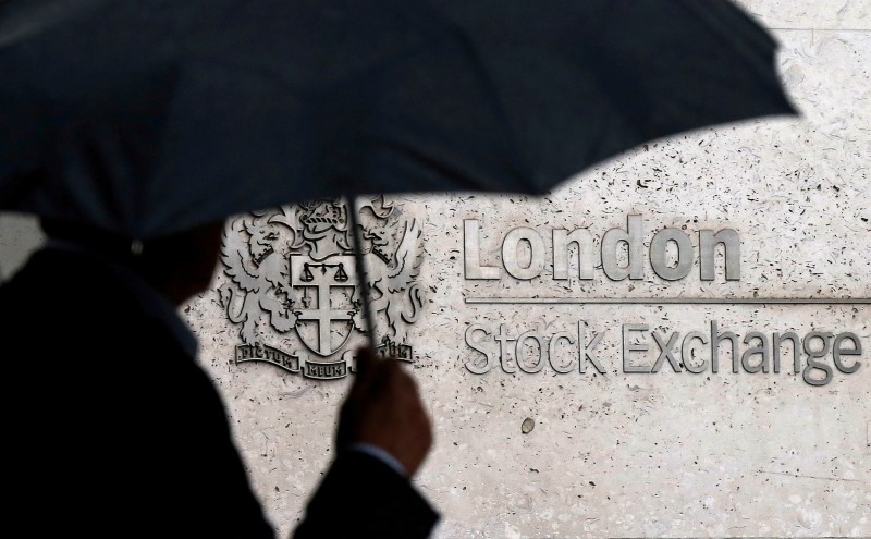 A man shelters under an umbrella as he walks past the London Stock Exchange in London, Britain, August 24, 2015. REUTERS/Suzanne Plunkett/File Photo