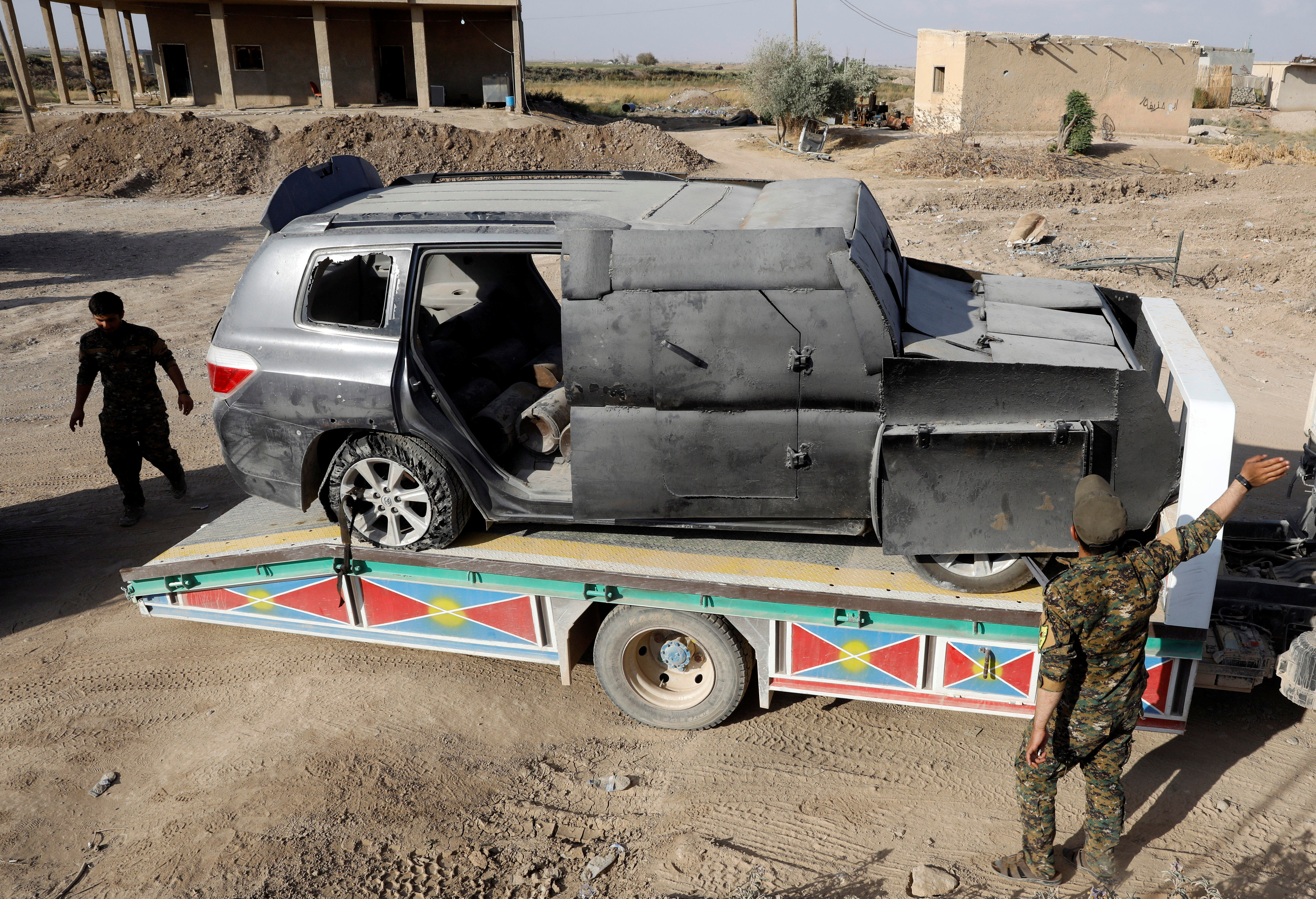Members of Syrian Democratic Forces transport a suicide car bomb used by the Islamic State militants in Raqqa