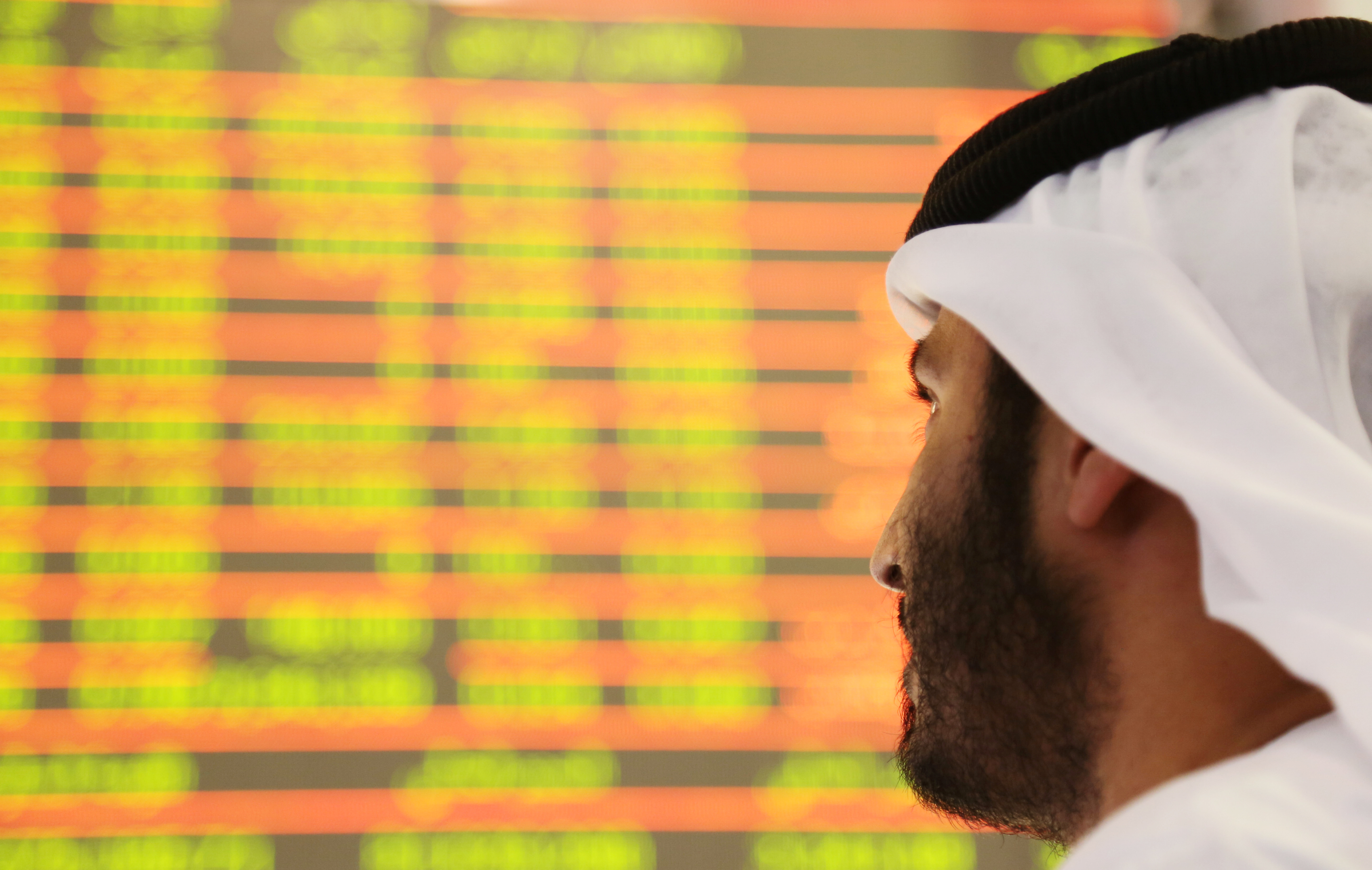 An investor looks at the screen at the Dubai International Financial Market in Dubai.