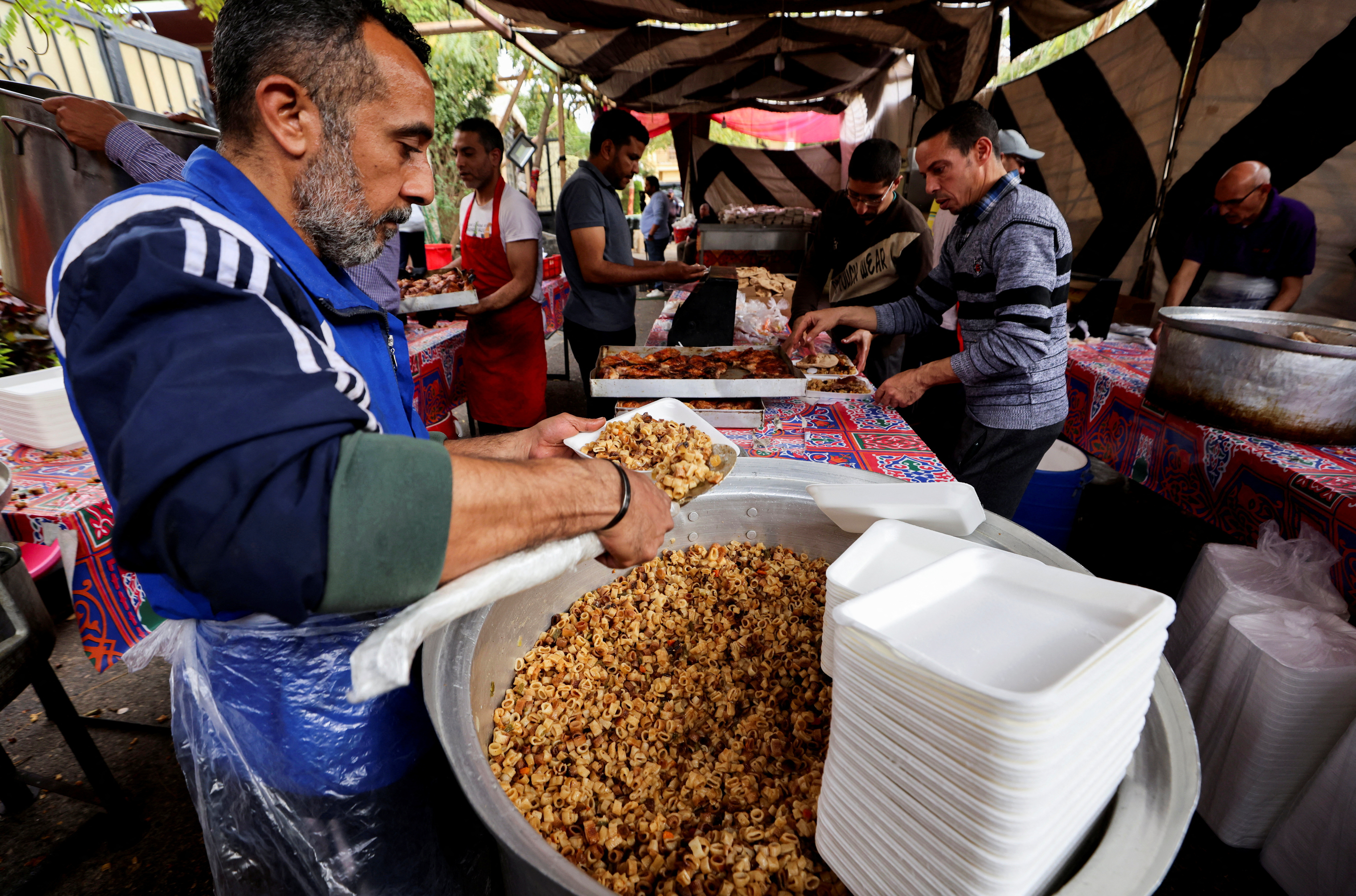 आर्थिक संकट के बीच रमजान के पवित्र महीने के दौरान काहिरा में गर्म भोजन वितरित किया जाता है