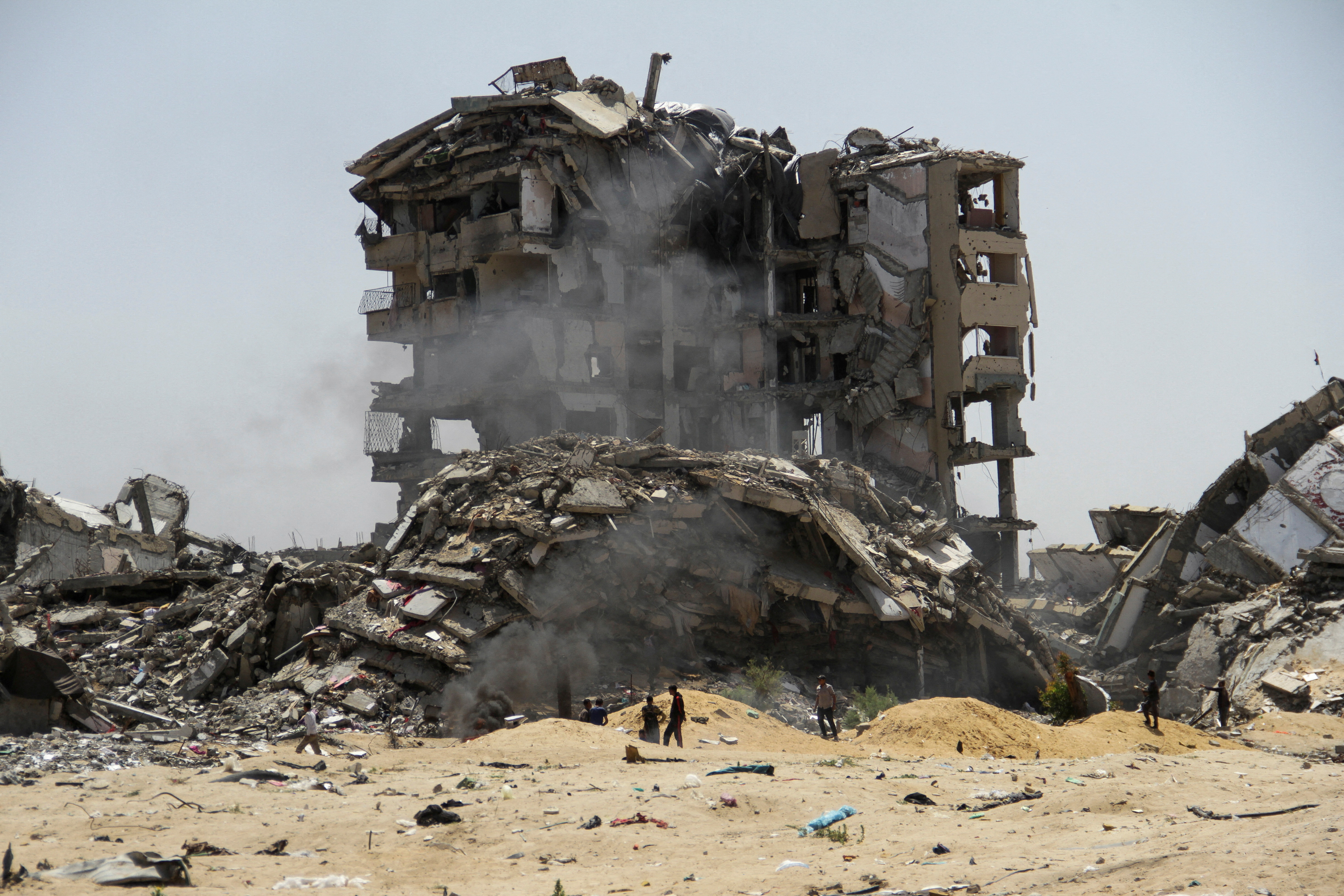 Palestinians walk past the rubble of residential buildings destroyed by Israeli strikes, amid the ongoing conflict between Israel and Hamas, in the northern Gaza Strip