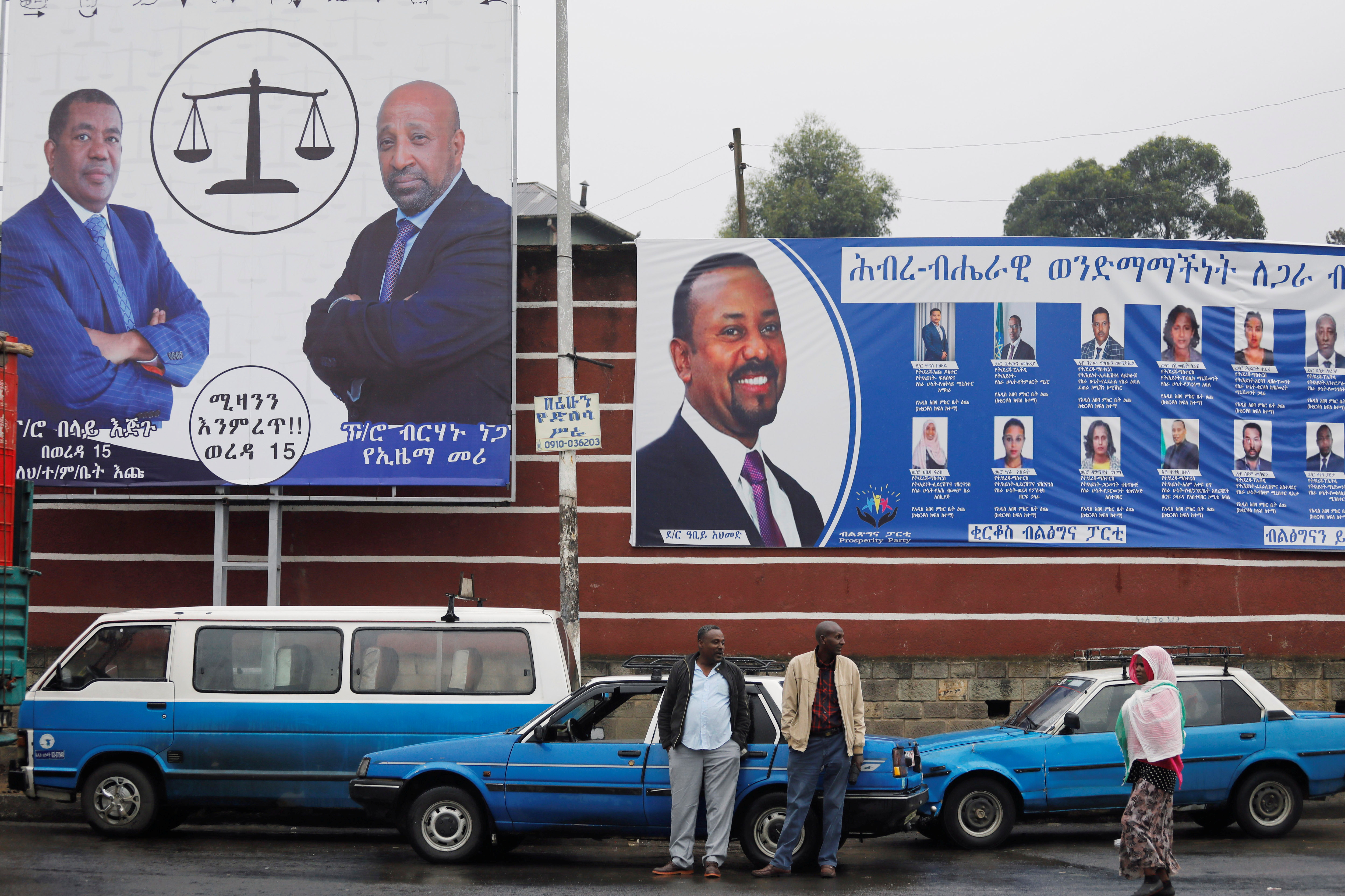 Taxi drivers stand in front of campaign banners ahead of Ethiopia's parliamentary and regional elections in Addis Ababa