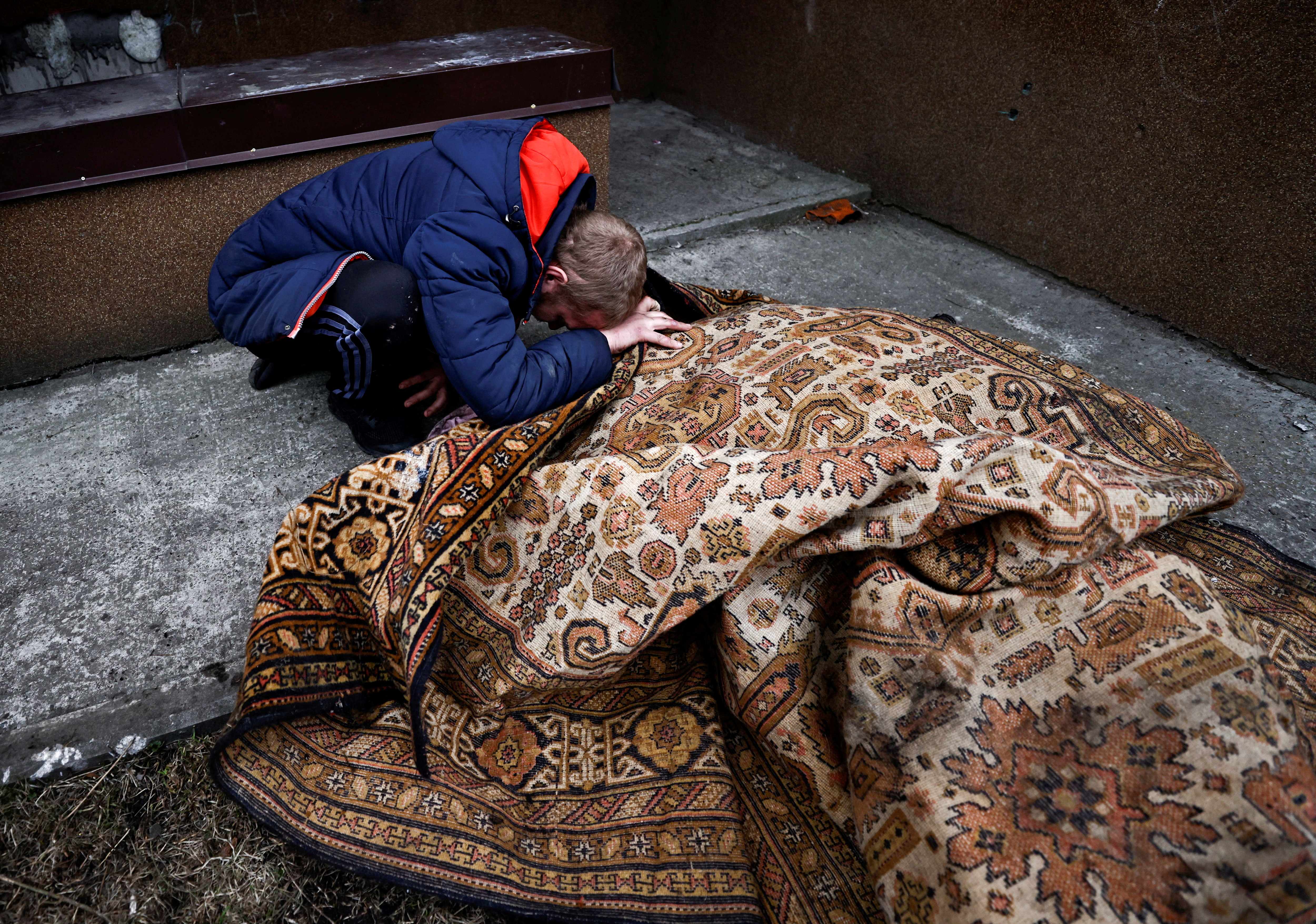 Serhii Lahovskyi mourns by the body of his friend Ihor Lytvynenko, who according to residents was killed by Russian Soldiers, in Bucha