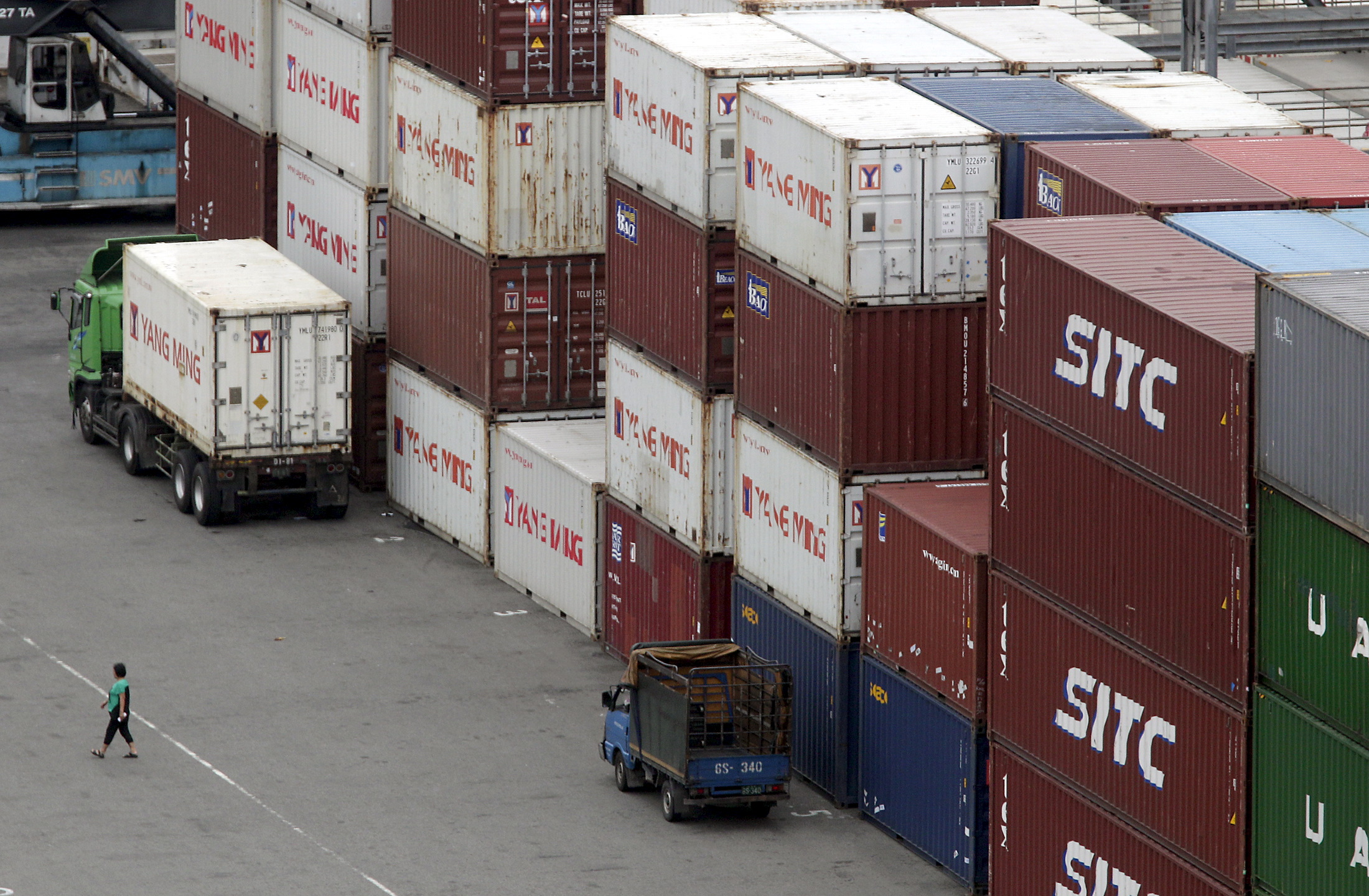 A person walks near containers at Keelung port, northern Taiwan
