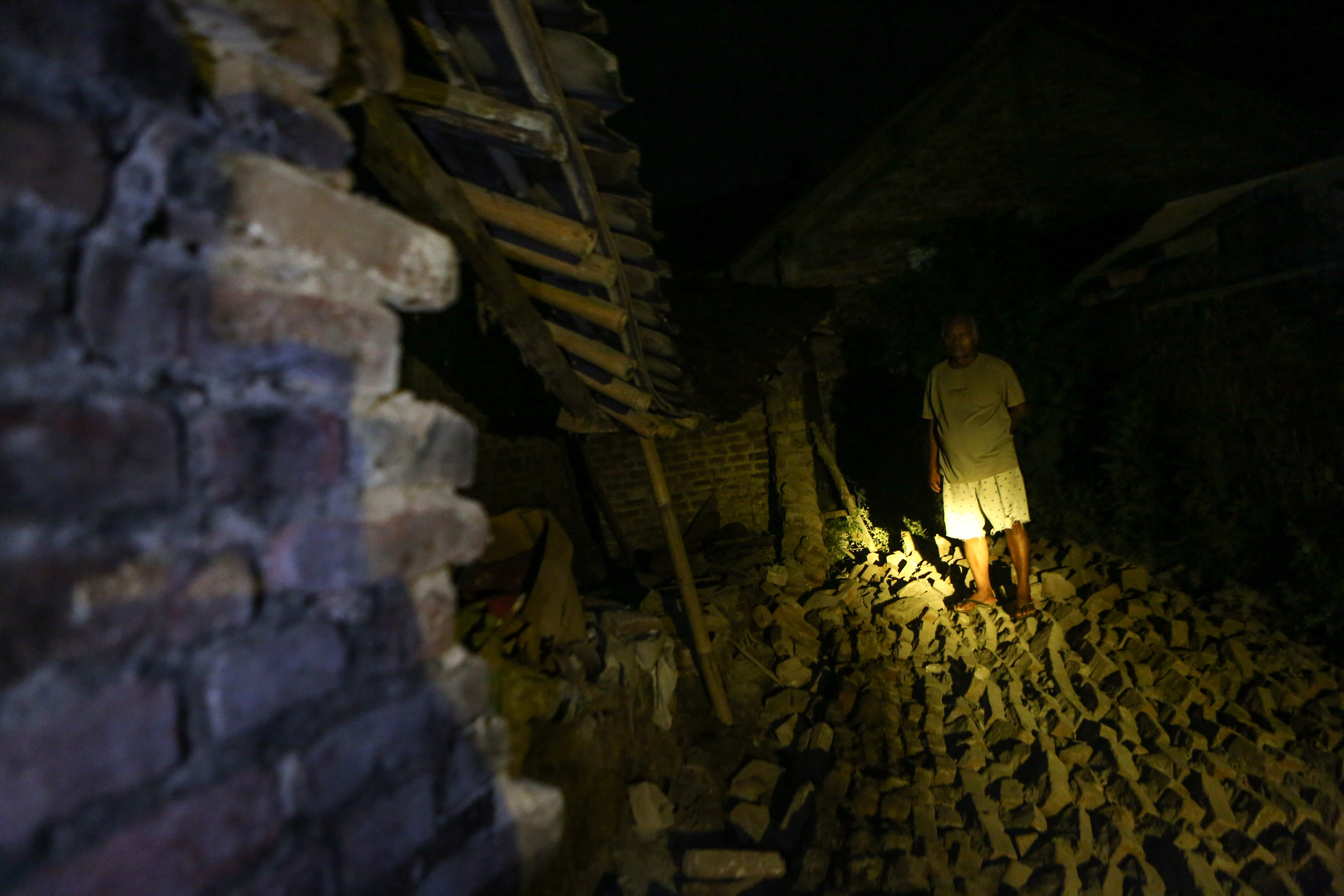 A resident stands near a damaged house after an earthquake struck off the Indonesian island of Java in Bantul