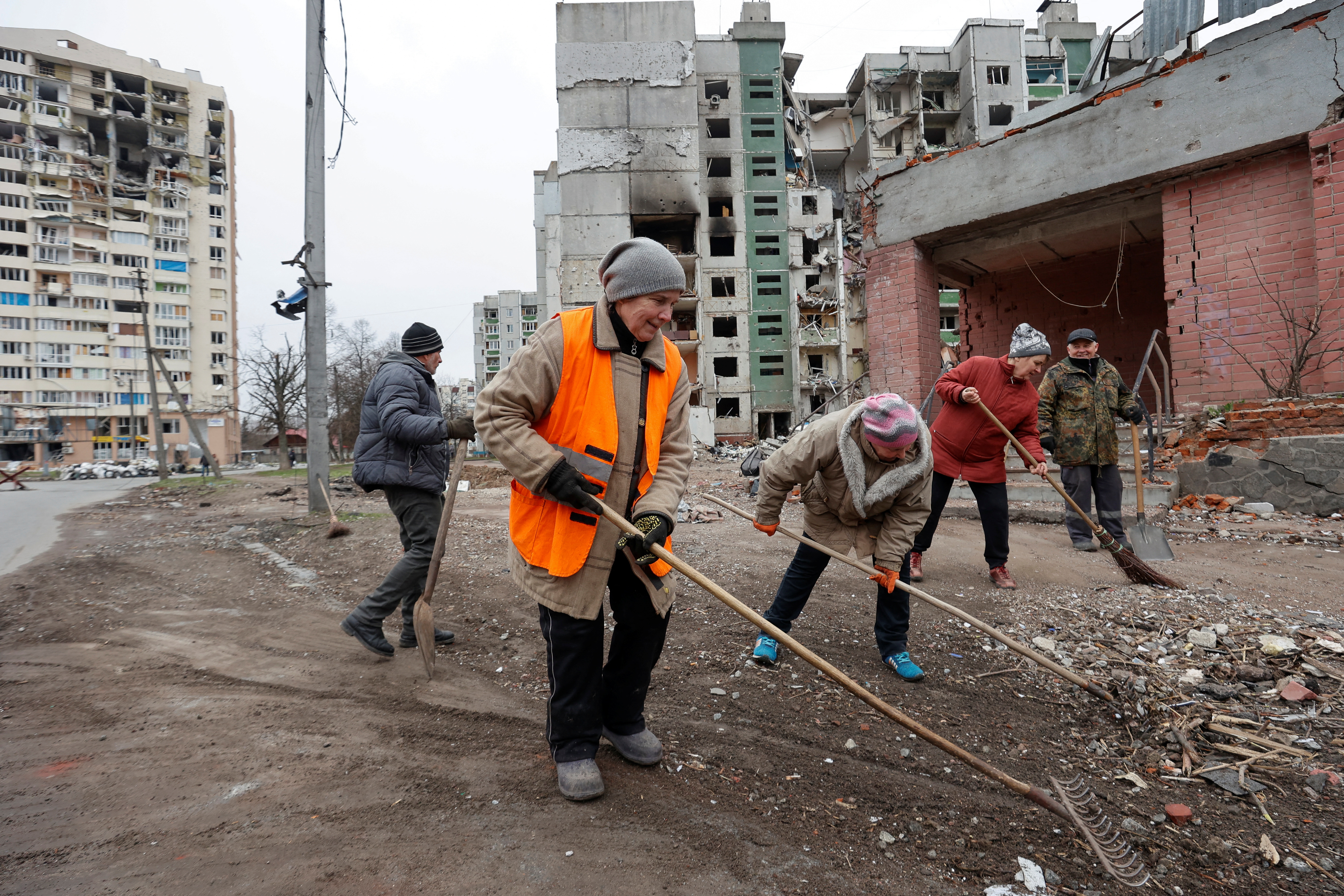 Municipal workers remove debris at a residential area damaged by heavy shelling and airstrikes in Chernihiv