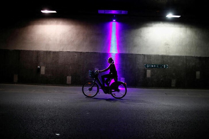 A woman rides an electric bike as the country eases lockdown measures taken to curb the spread of the coronavirus disease (COVID-19) in Paris