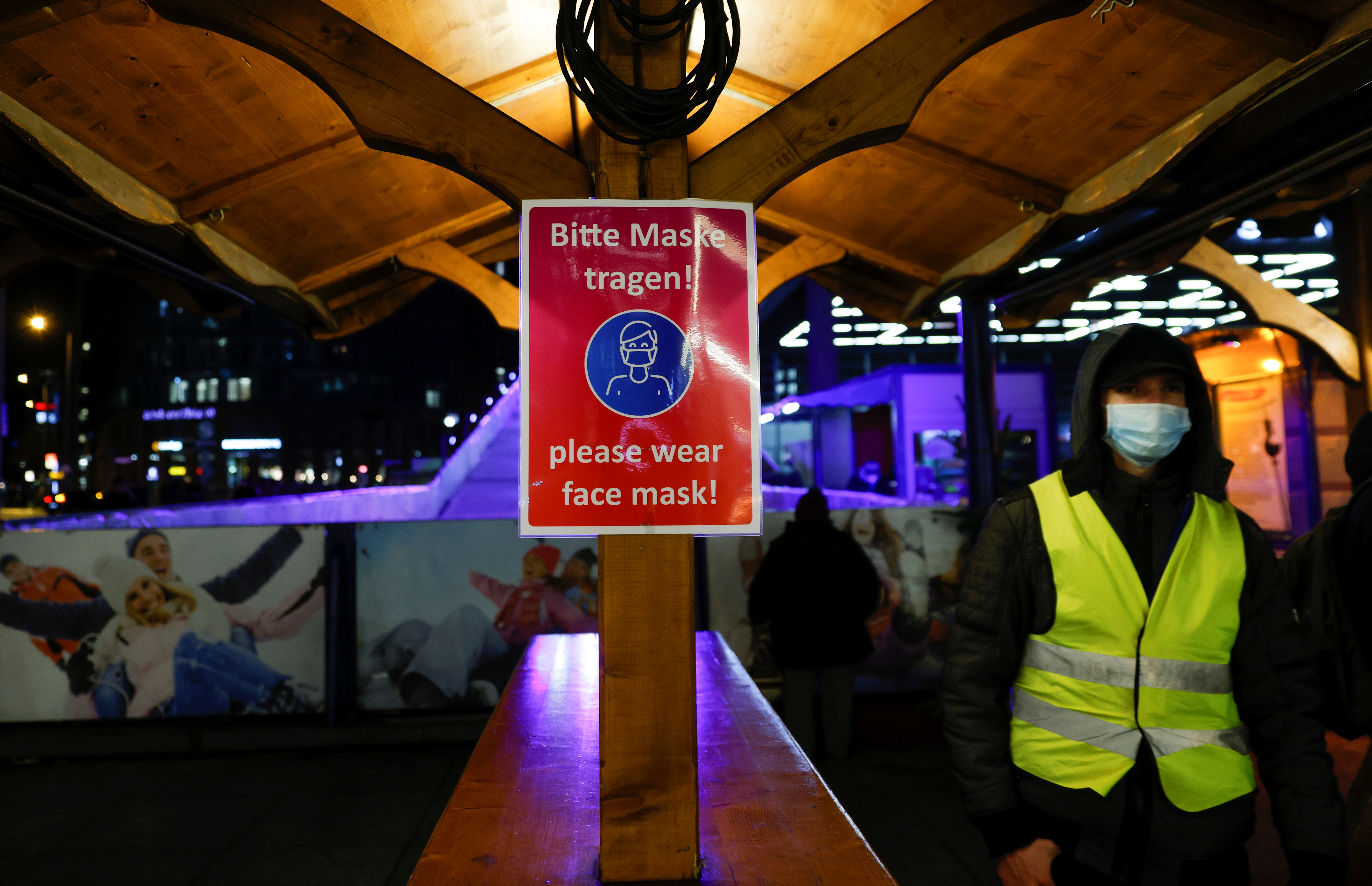 A sign requesting visitors to wear face masks is seen at a Christmas market as the spread of the coronavirus disease (COVID-19) continues in Berlin, Germany, November 30, 2021. REUTERS/Michele Tantussi/file photo