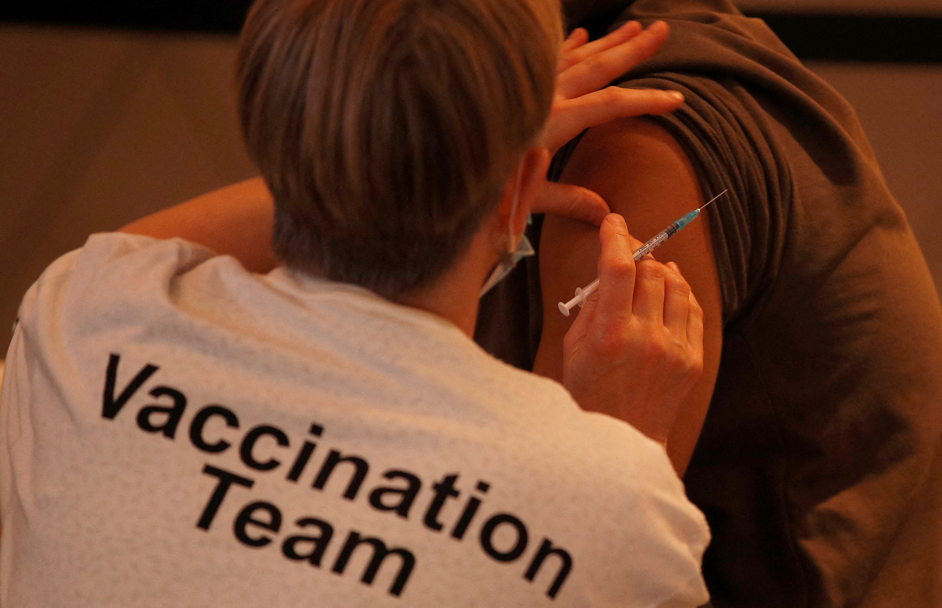 A healthcare professional administers a booster vaccine at a coronavirus disease (COVID-19) pop-up vaccination centre at Wembley Stadium in London