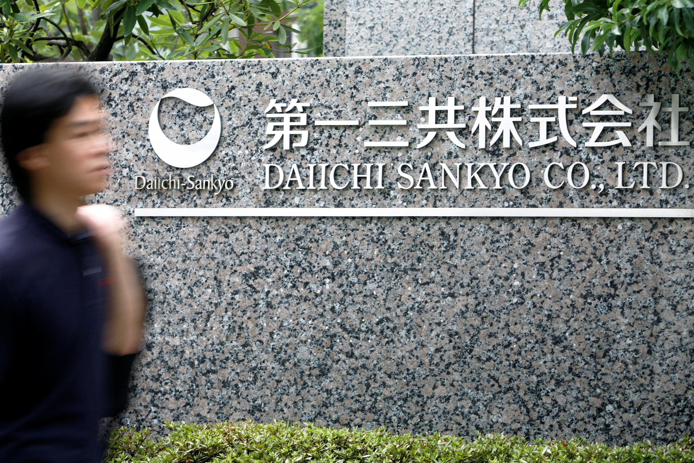 Man walks past a sign of Daiichi Sankyo Co., Ltd. at the company's head office in Tokyo