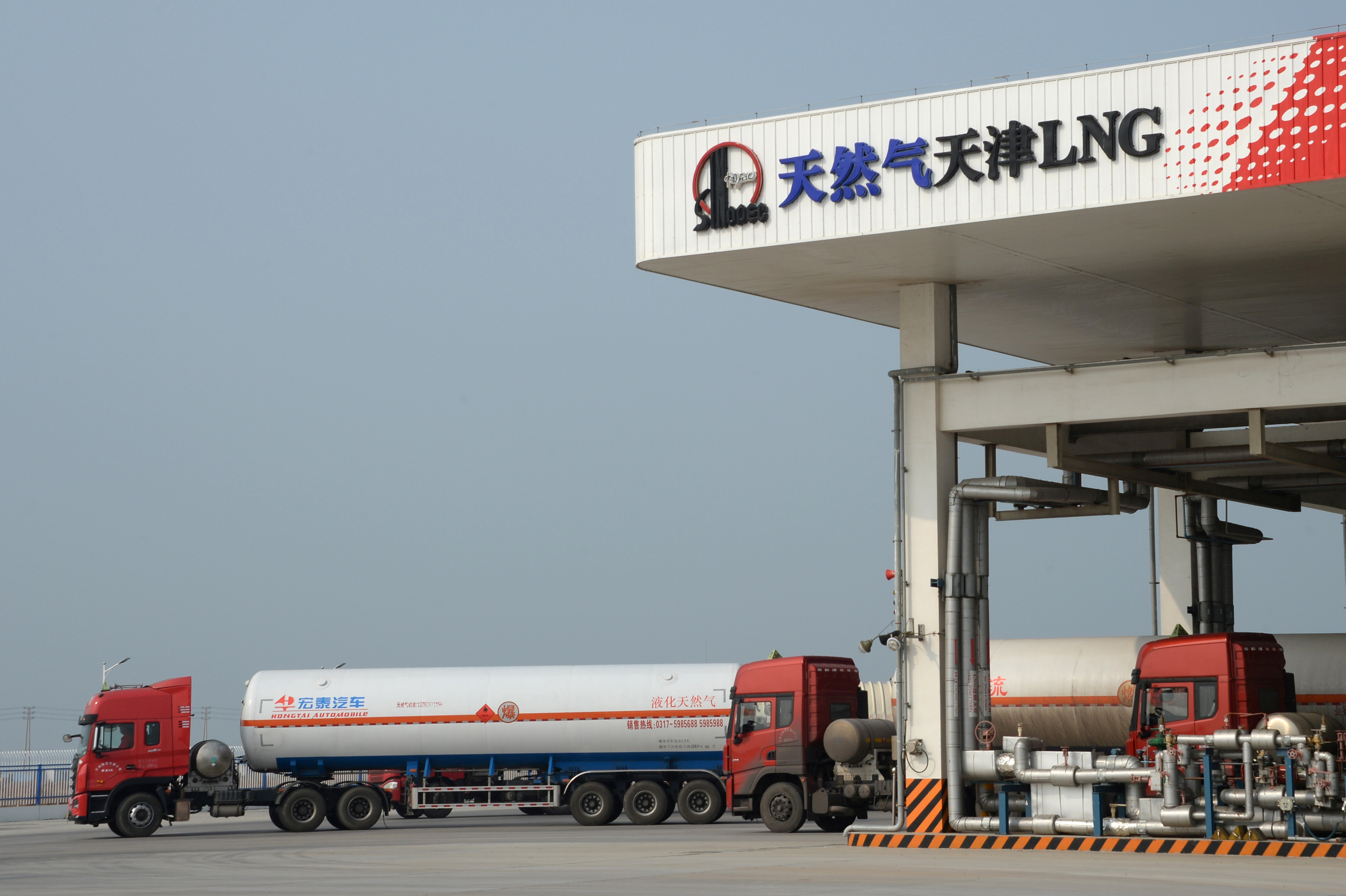Trucks carrying liquefied natural gas (LNG) are seen at Sinopec's LNG terminal in Tianjin
