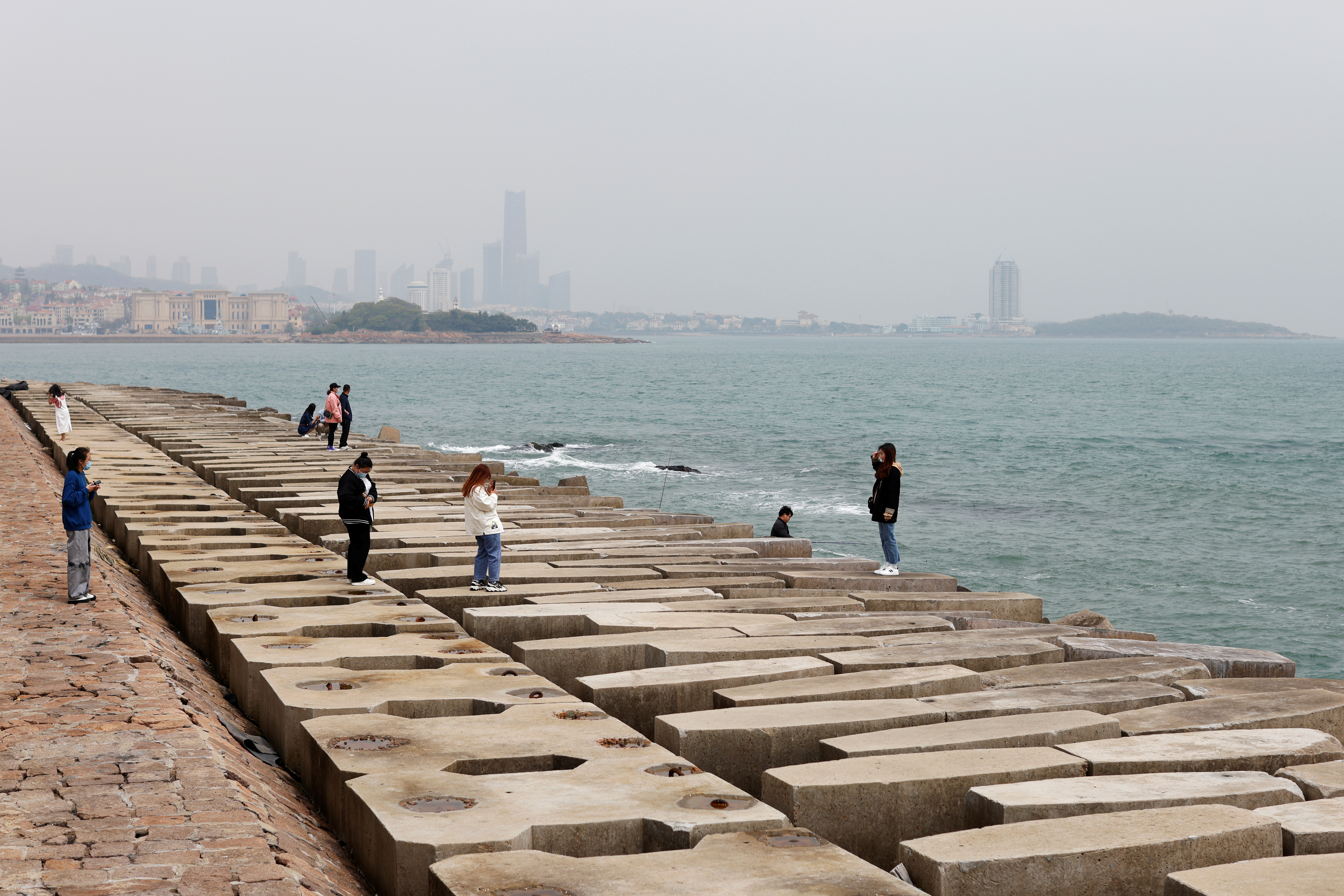 Visitor poses for pictures on the coast of Qingdao