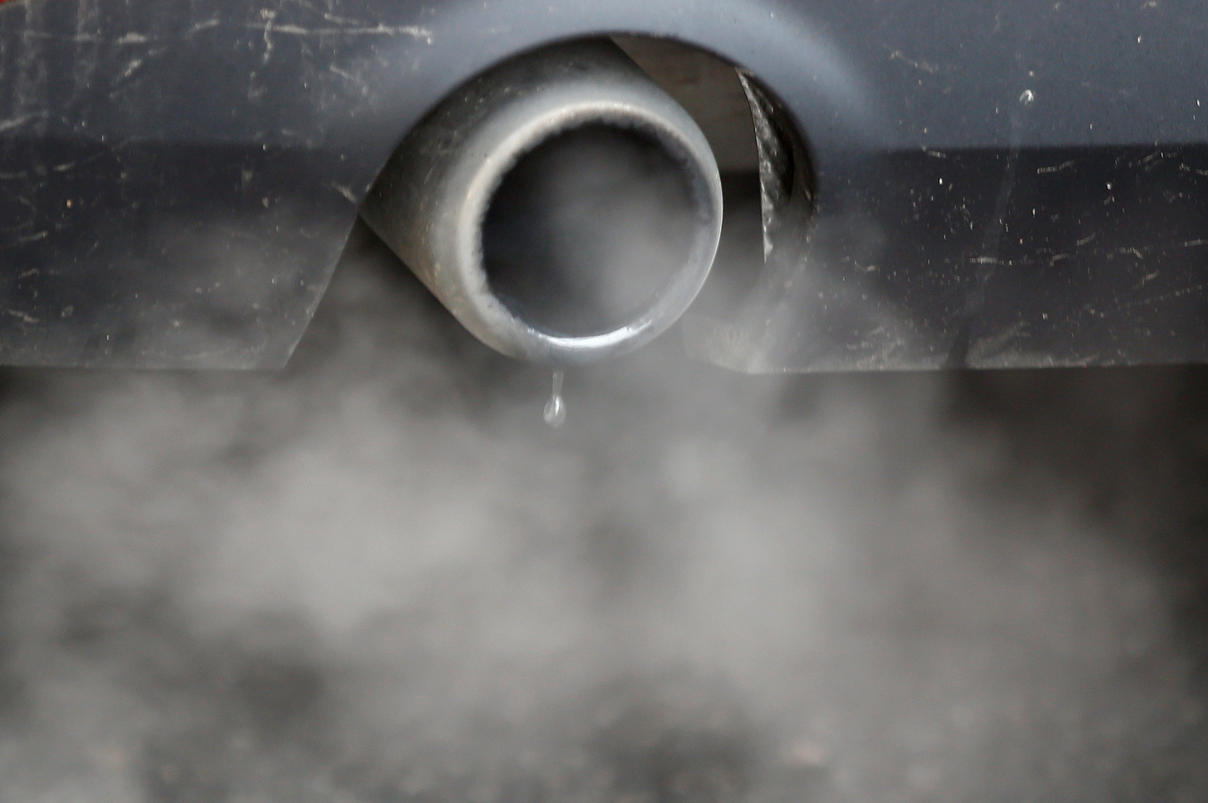 An exhaust emits fumes as a car is driven through Richmond in London