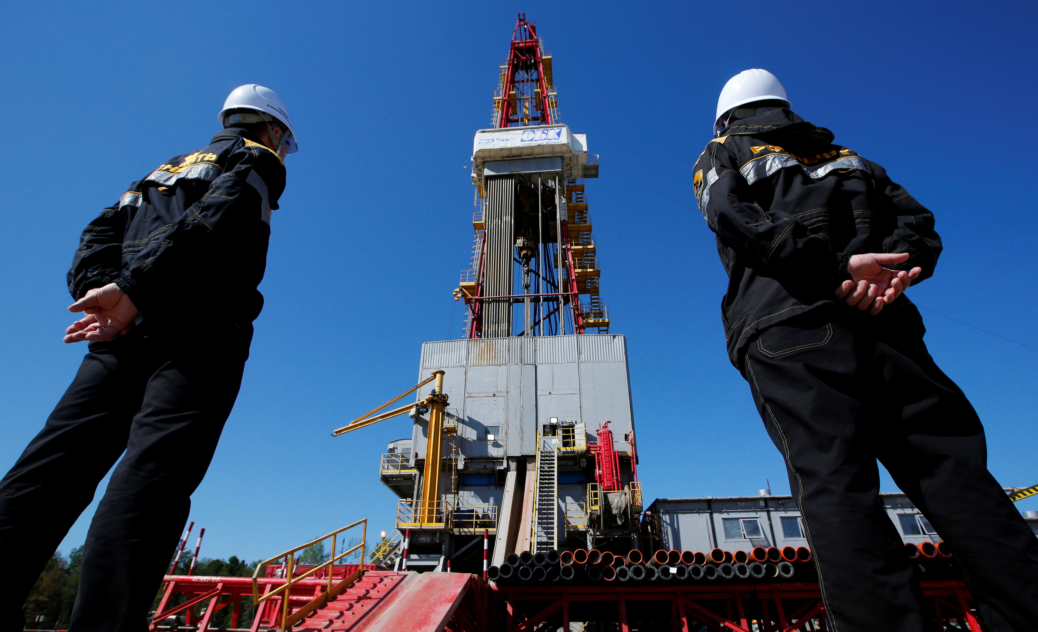 File photo of workers looking at drilling rig at well pad of Rosneft-owned Prirazlomnoye oil field outside Nefteyugansk