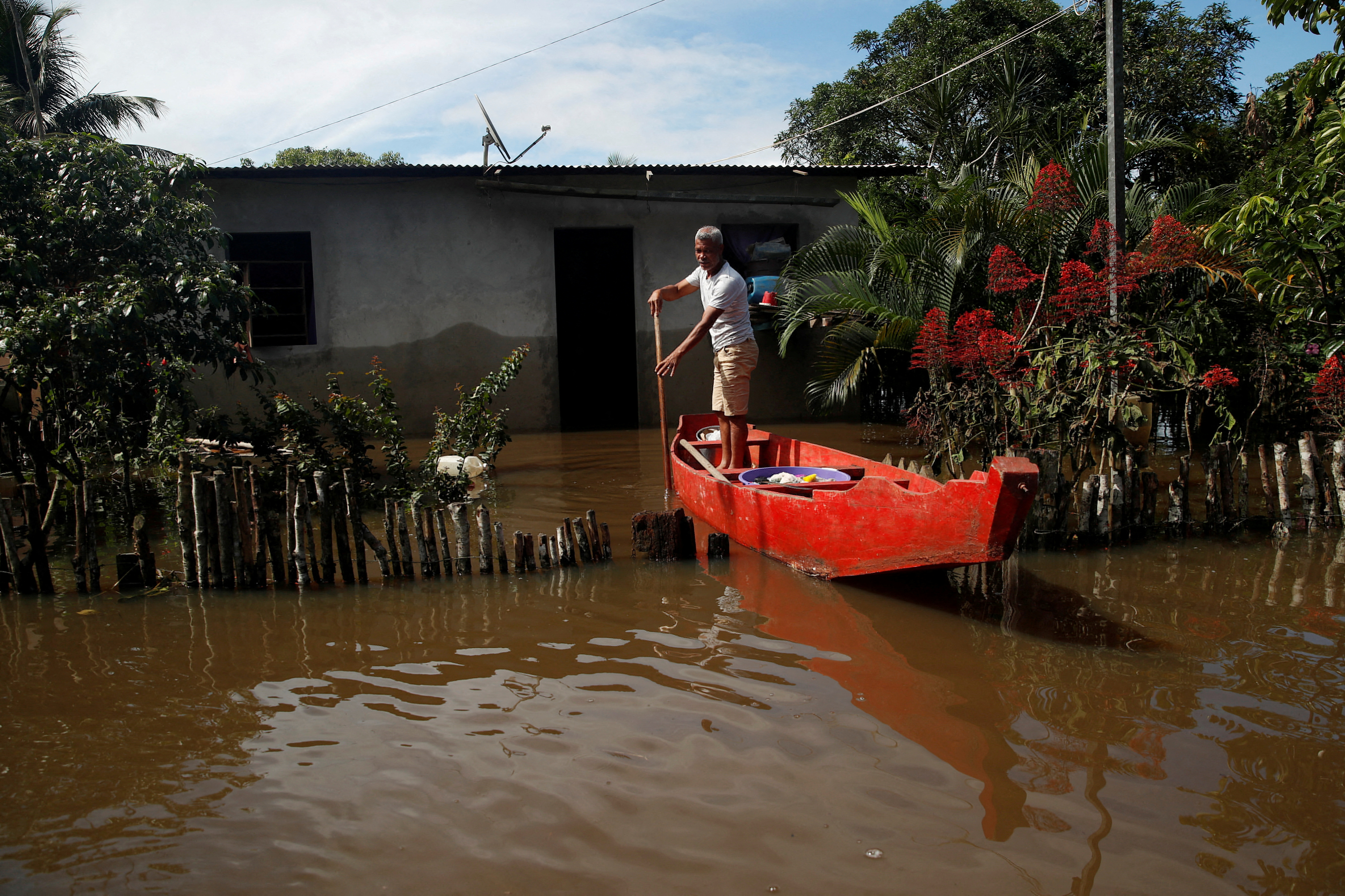 Valfredo Alcantara Pereira, 55, uses a canoe to reach his partially submerged house in a flooded street, in Ilheus, Bahia state, Brazil December 30, 2021. REUTERS/Amanda Perobelli/File Photo