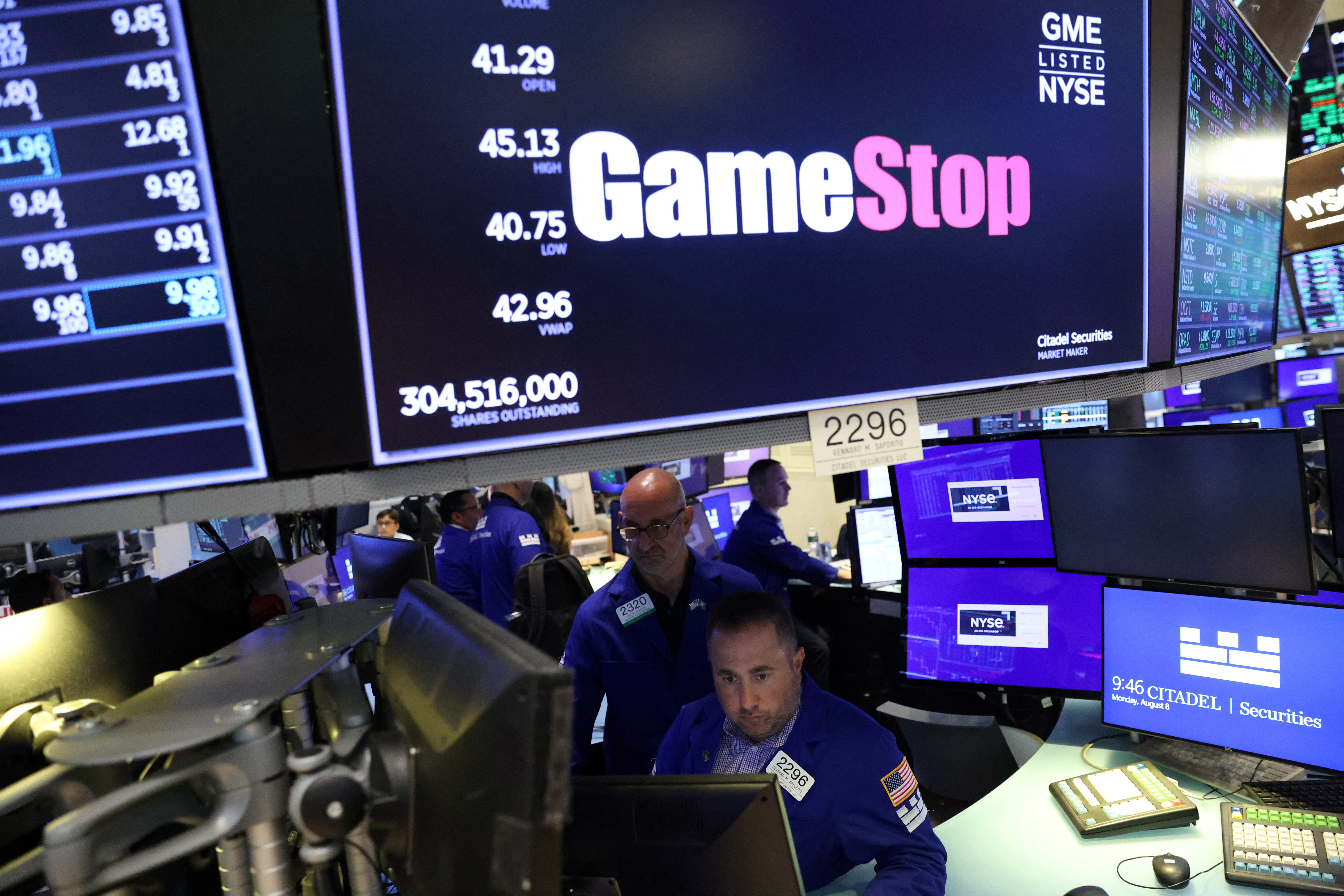 Traders work under signage for GameStop Corp. (NYSE: GME) on the trading floor at the New York Stock Exchange (NYSE) in Manhattan, New York City