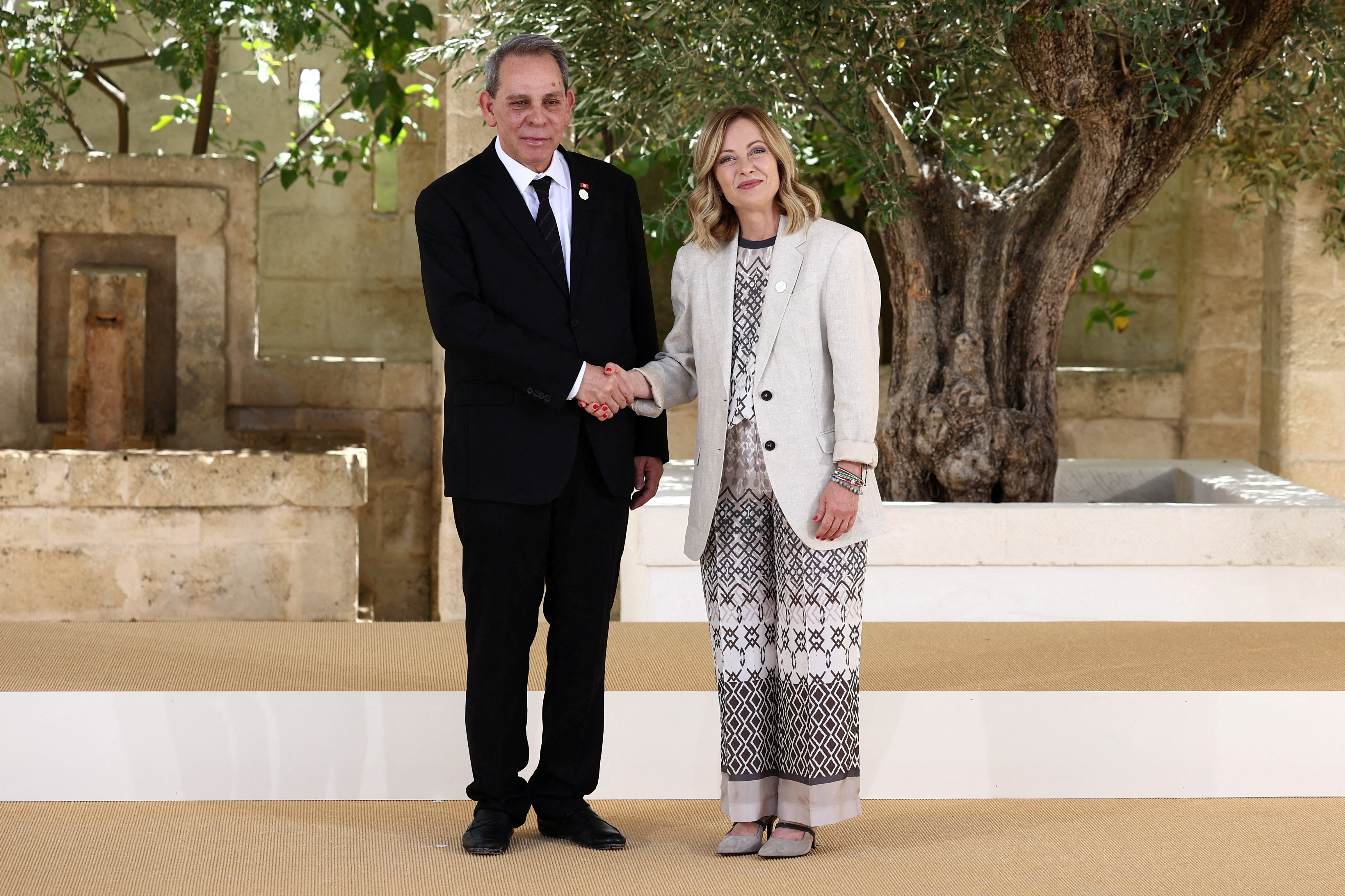 Tunisia's Prime Minister Ahmed Hachani  is welcomed by Italian Prime Minister Giorgia Meloni on the second day of a G7 summit in Italy