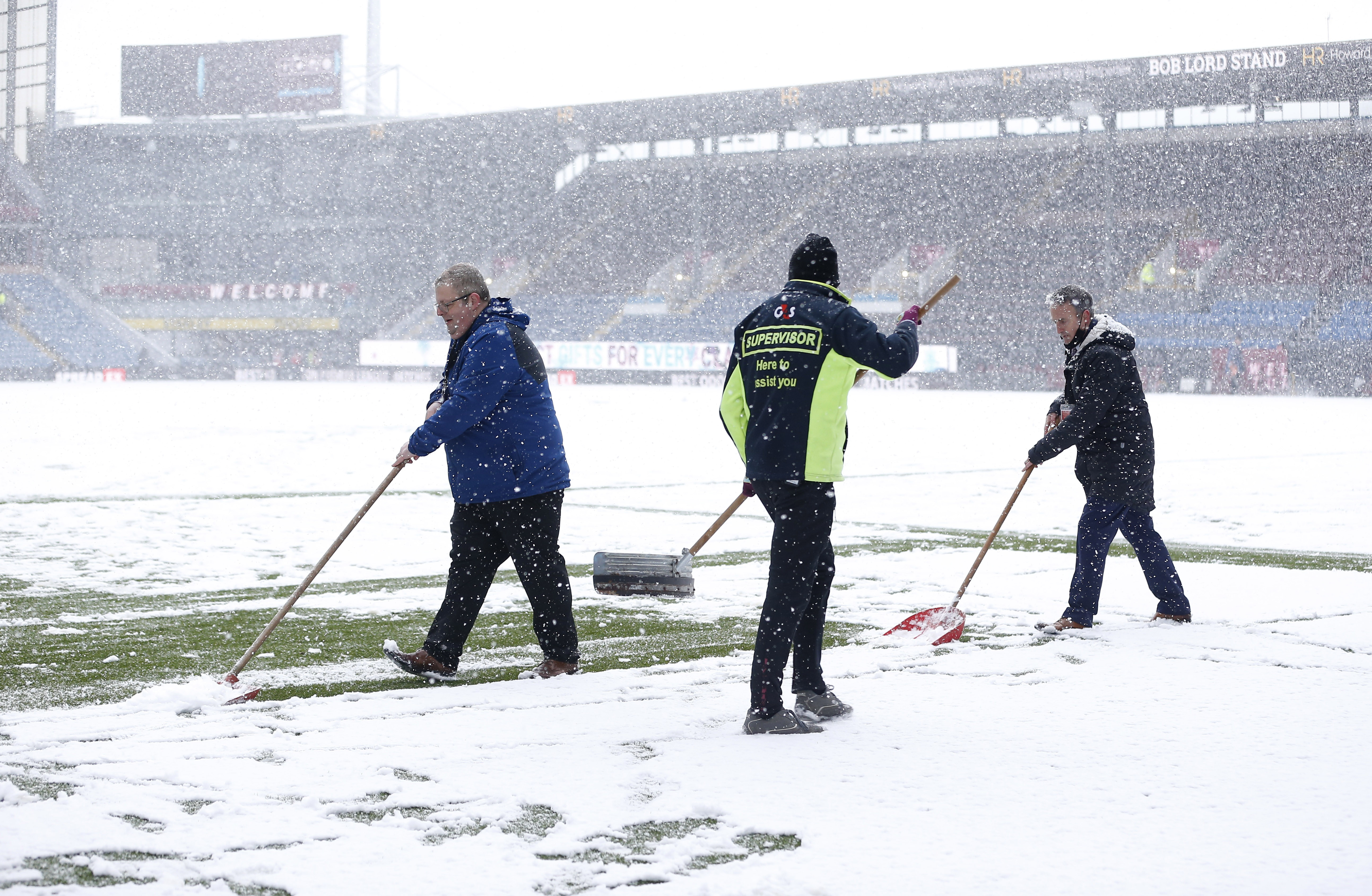 Soccer Football - Premier League - Burnley v Tottenham Hotspur - Turf Moor, Burnley, Britain - November 28, 2021 Ground staff clear snow off the pitch before the match REUTERS/Craig Brough  
