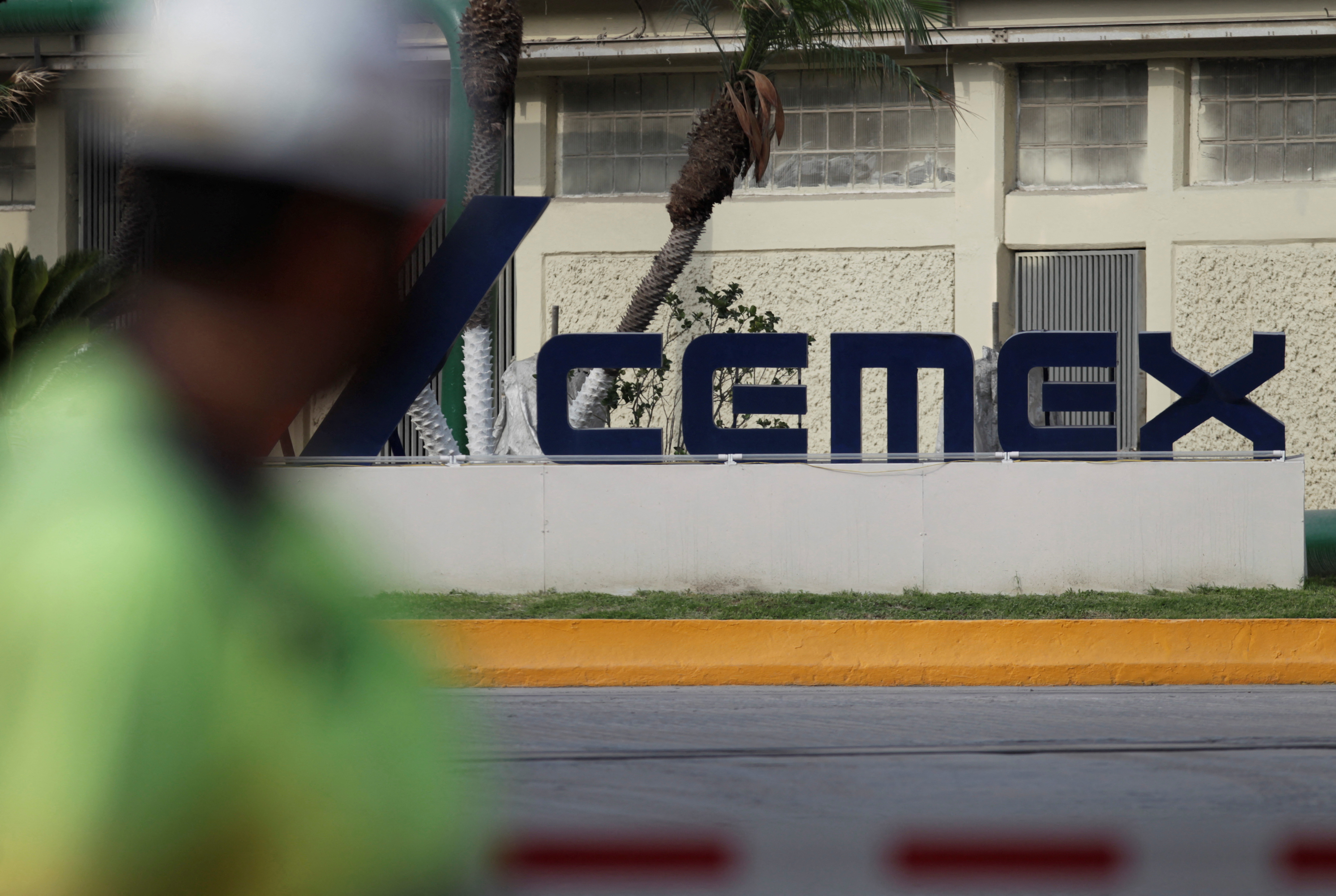 A worker walks past outside the main entrance from a concrete plant of Mexican cement maker CEMEX, in Monterrey