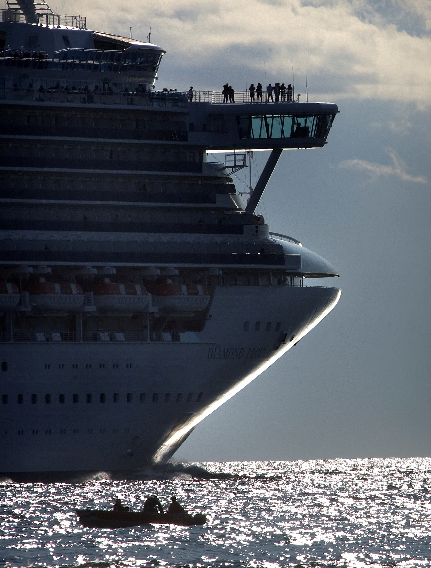 Cruise ship Diamond Princess passes by a small boat as it heads out to sea from Vancouver