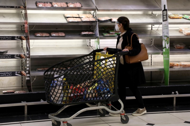 Shopper walks past near-empty shelves at a supermarket in Beirut