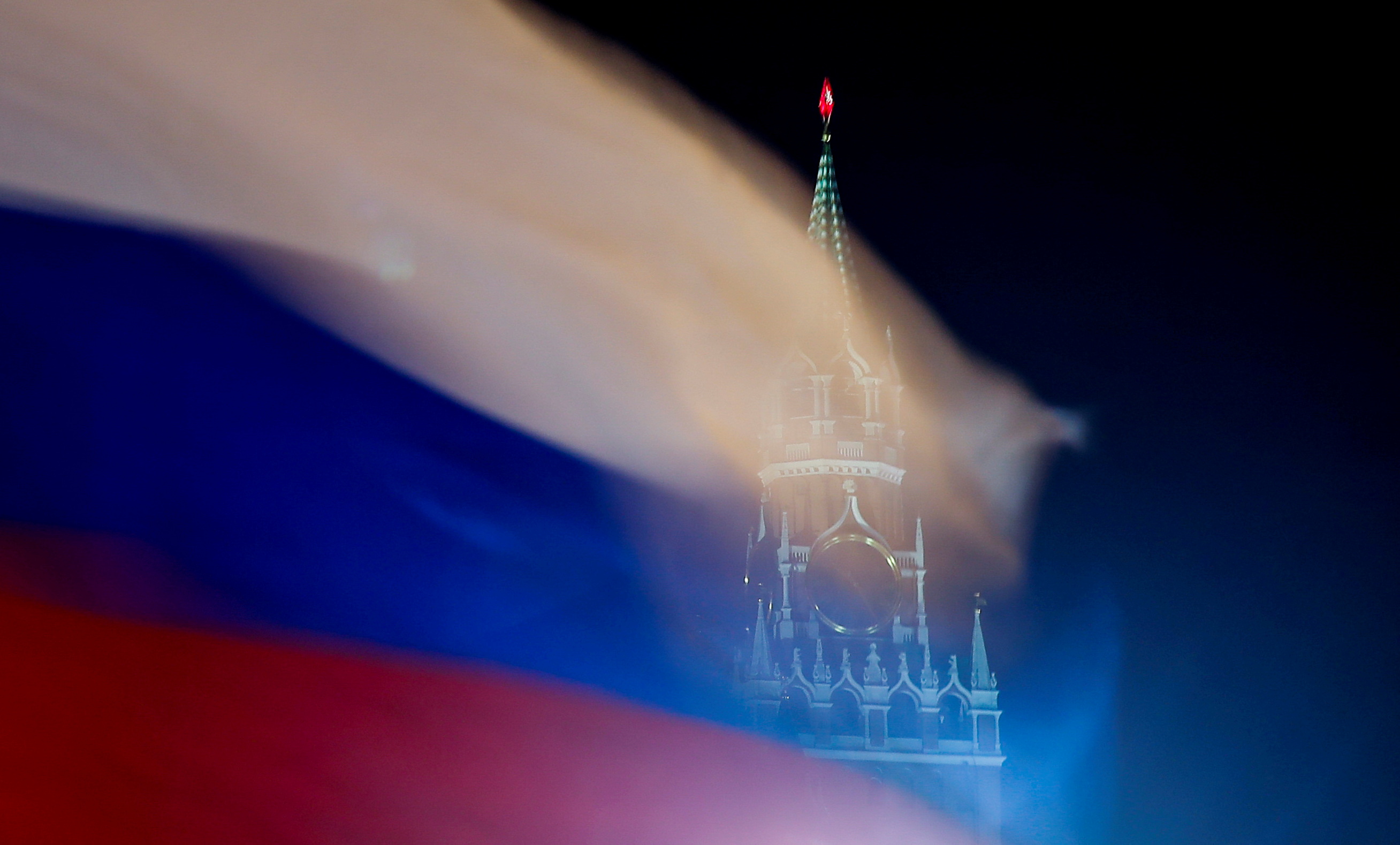 A Russian flag flies with the Spasskaya tower of Moscow's Kremlin in the background