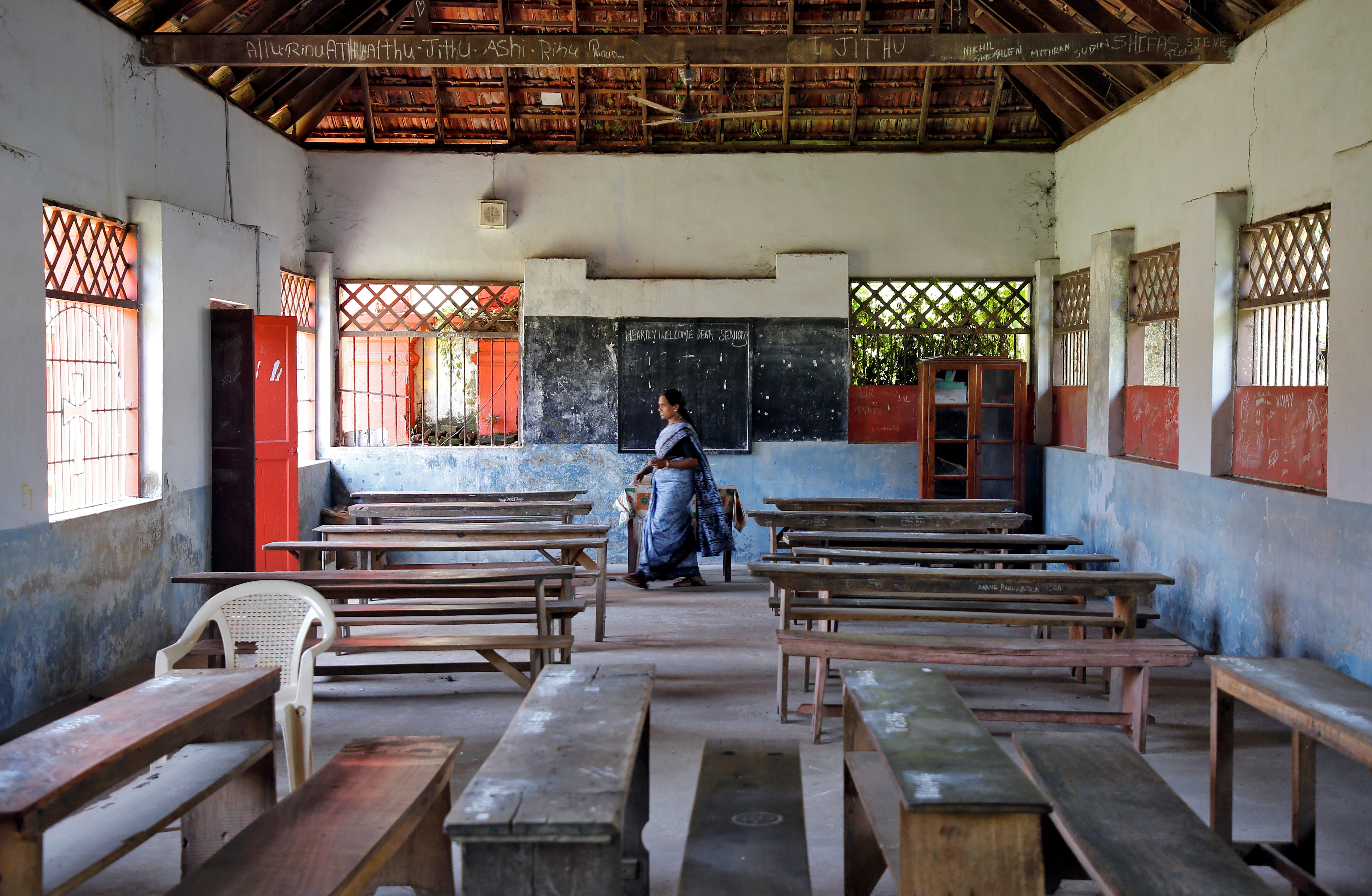 A staff member walks inside an empty classroom of a school after Kerala state government ordered the closure of schools across the state, amid coronavirus fears, in Kochi