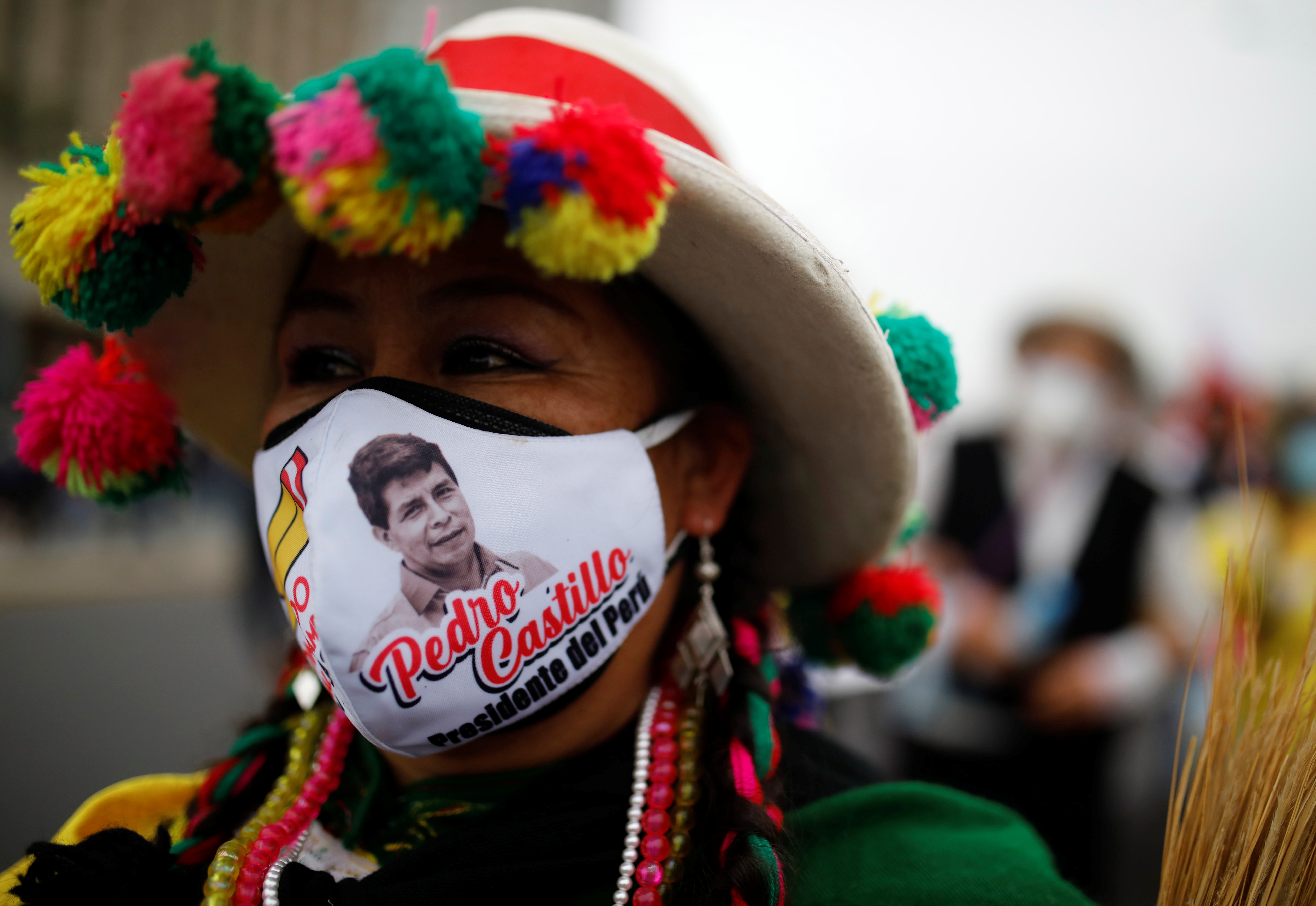 A supporter wearing a face mask with the image of Peru's presidential candidate Pedro Castillo marches in Lima, Peru June 26, 2021. REUTERS/Sebastian Castaneda