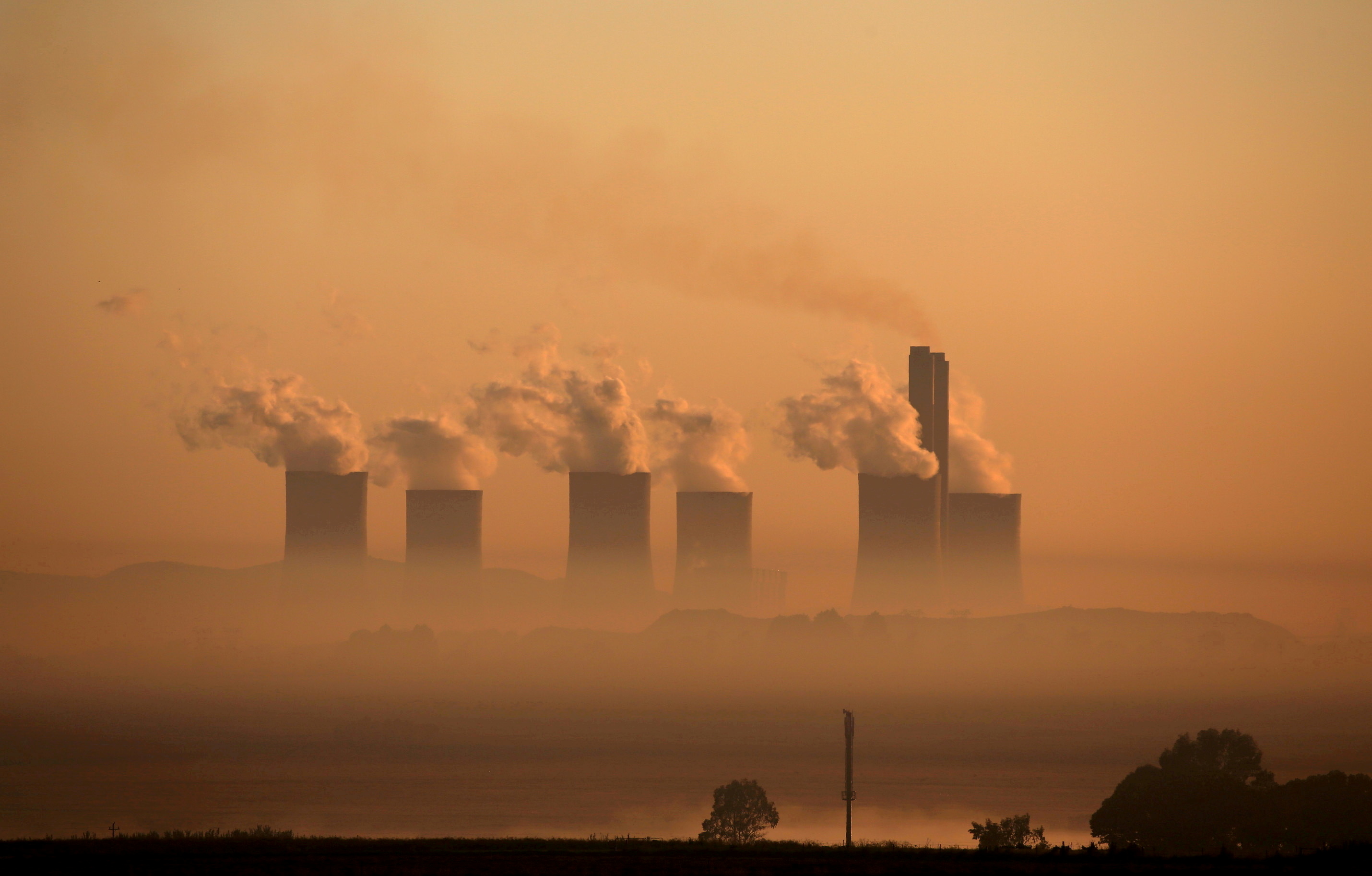 Steam rises at sunrise from the  Lethabo Power Station, a coal-fired power station owned by state power utility ESKOM near Sasolburg