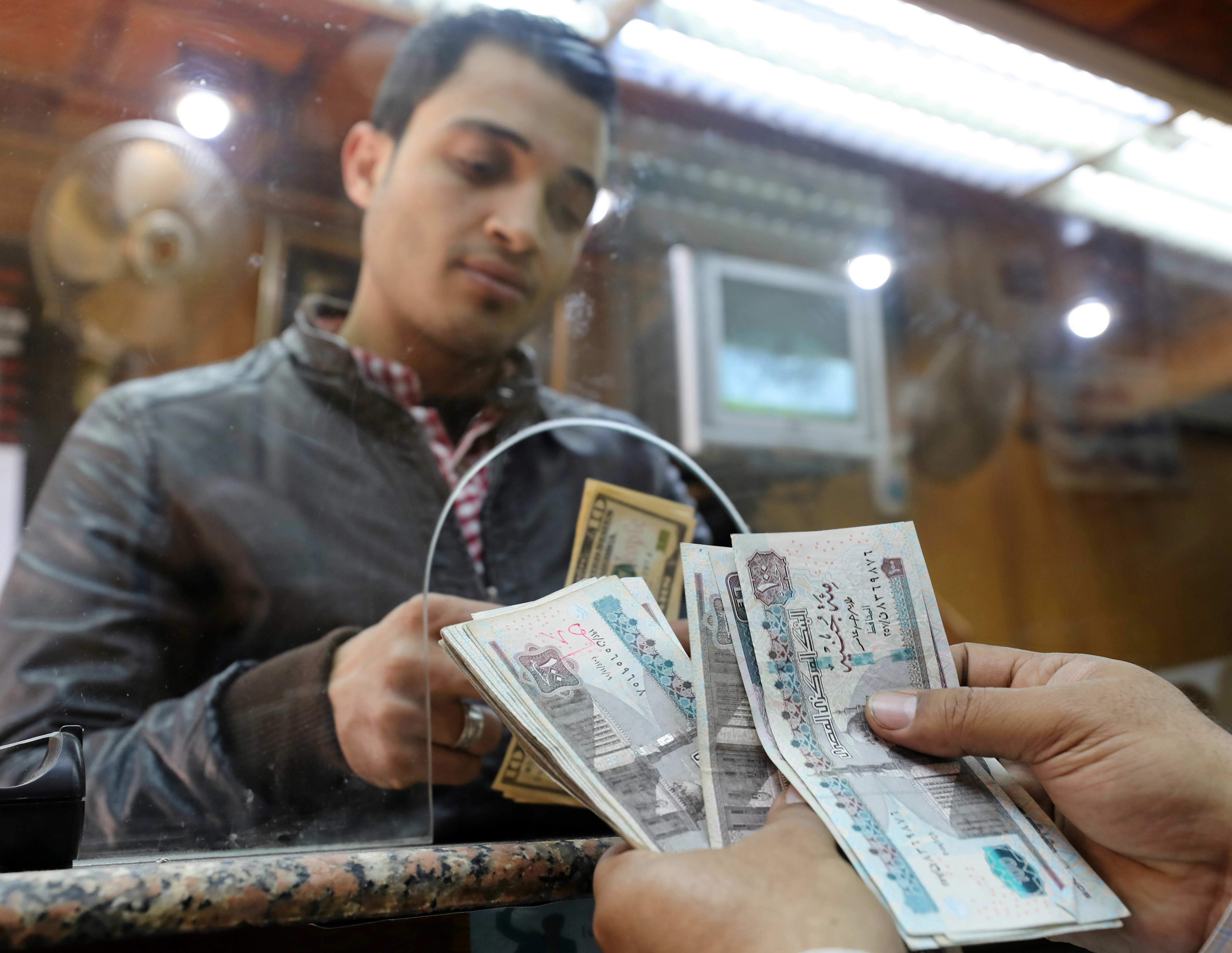 A customer exchanges U.S. dollars to Egyptian pounds in a foreign exchange office in central Cairo