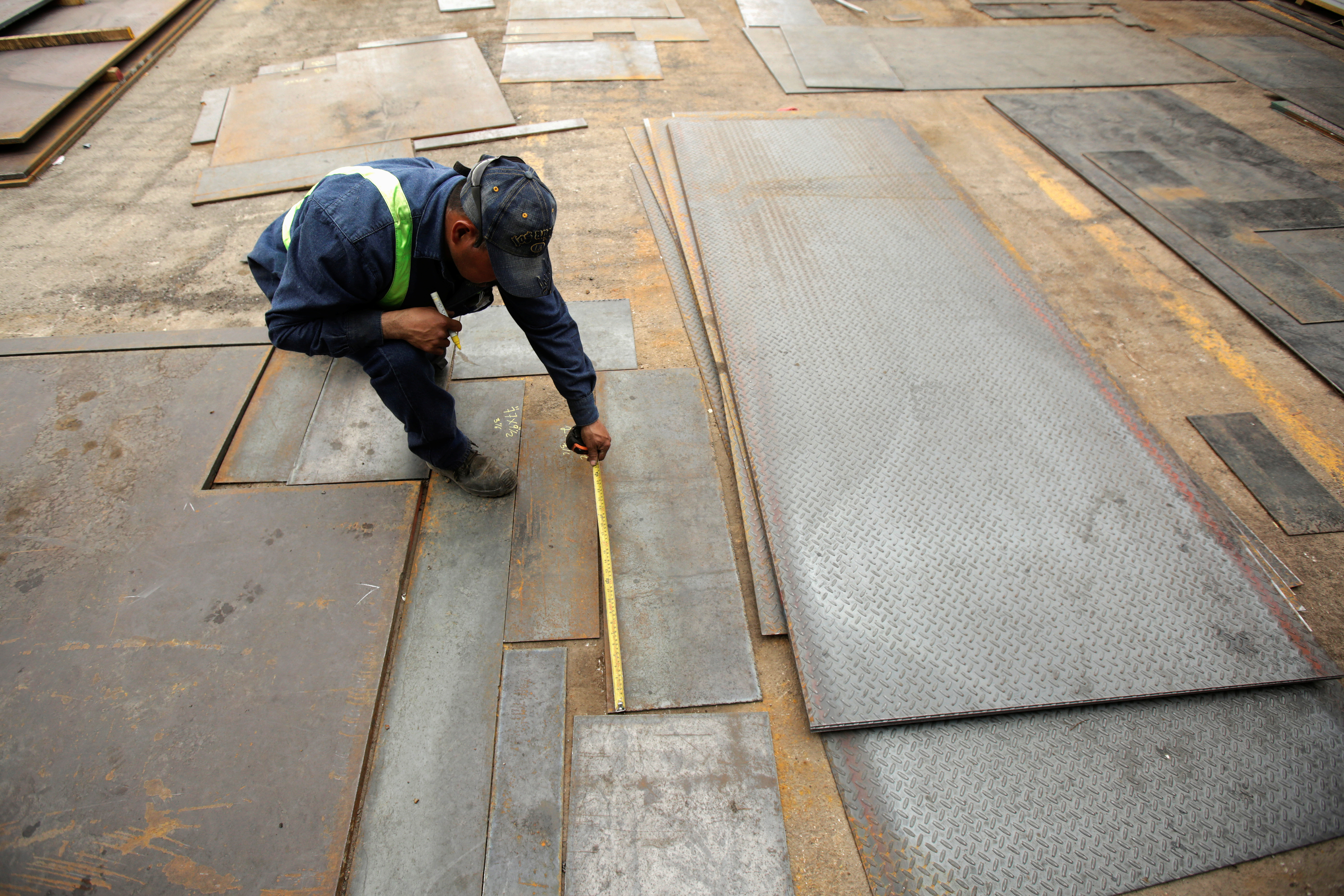 An employee measures steel plates at Kalisch Steel factory in Ciudad Juarez