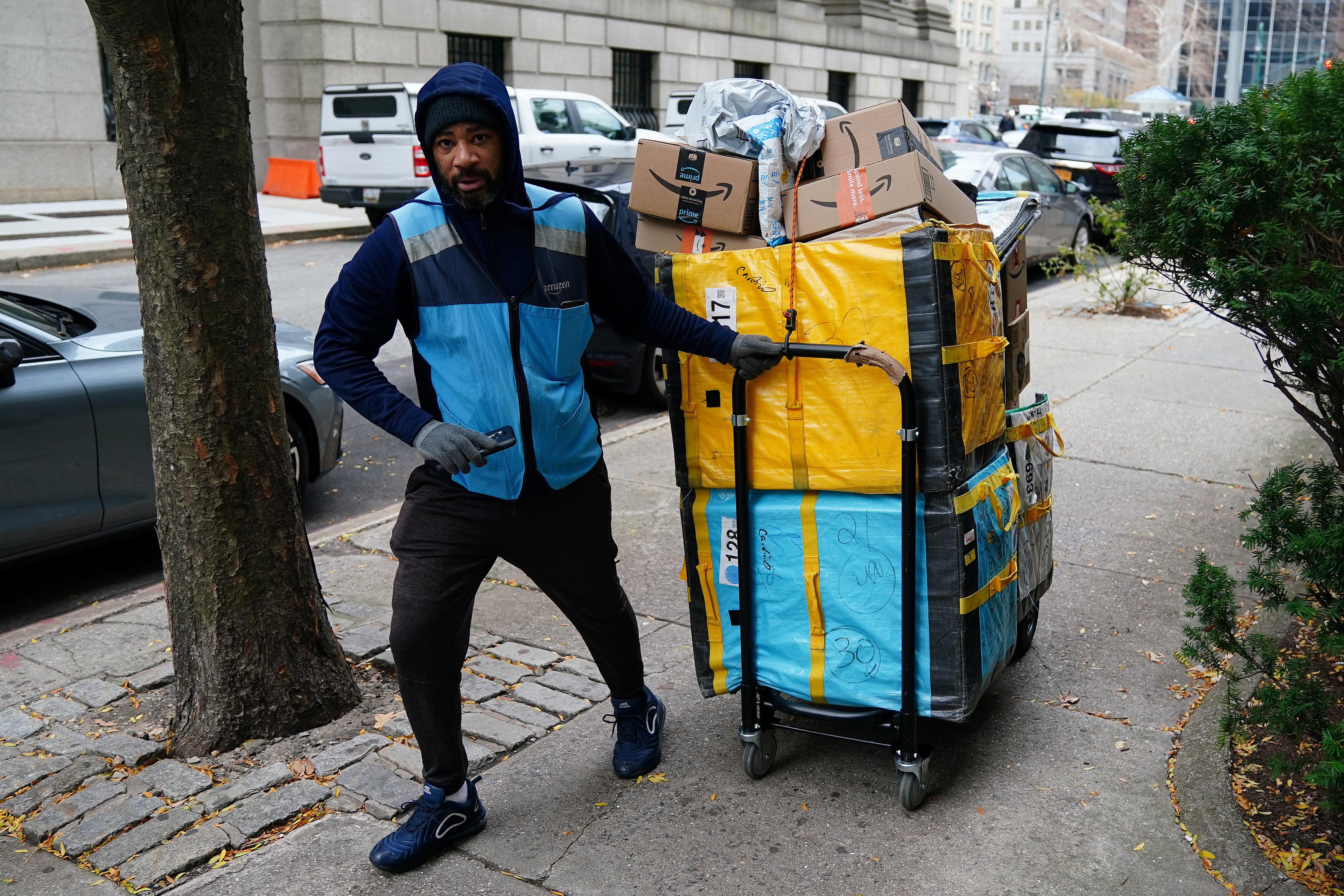 An Amazon delivery person pulls a cart full of packages in New York