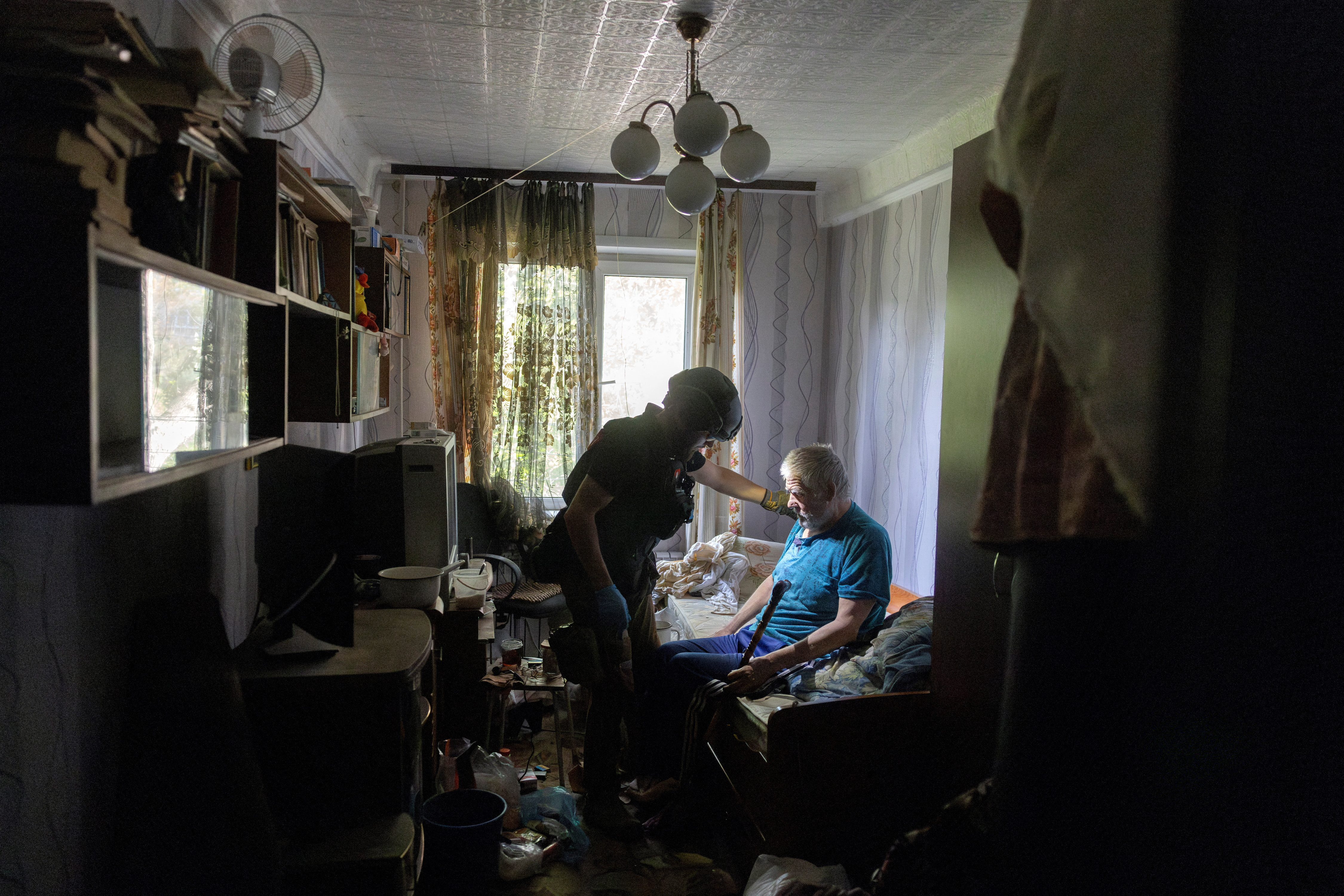 A volunteer of East SOS assists a resident who is evacuating his home because of Russian advances in Selydove near Pokrovsk