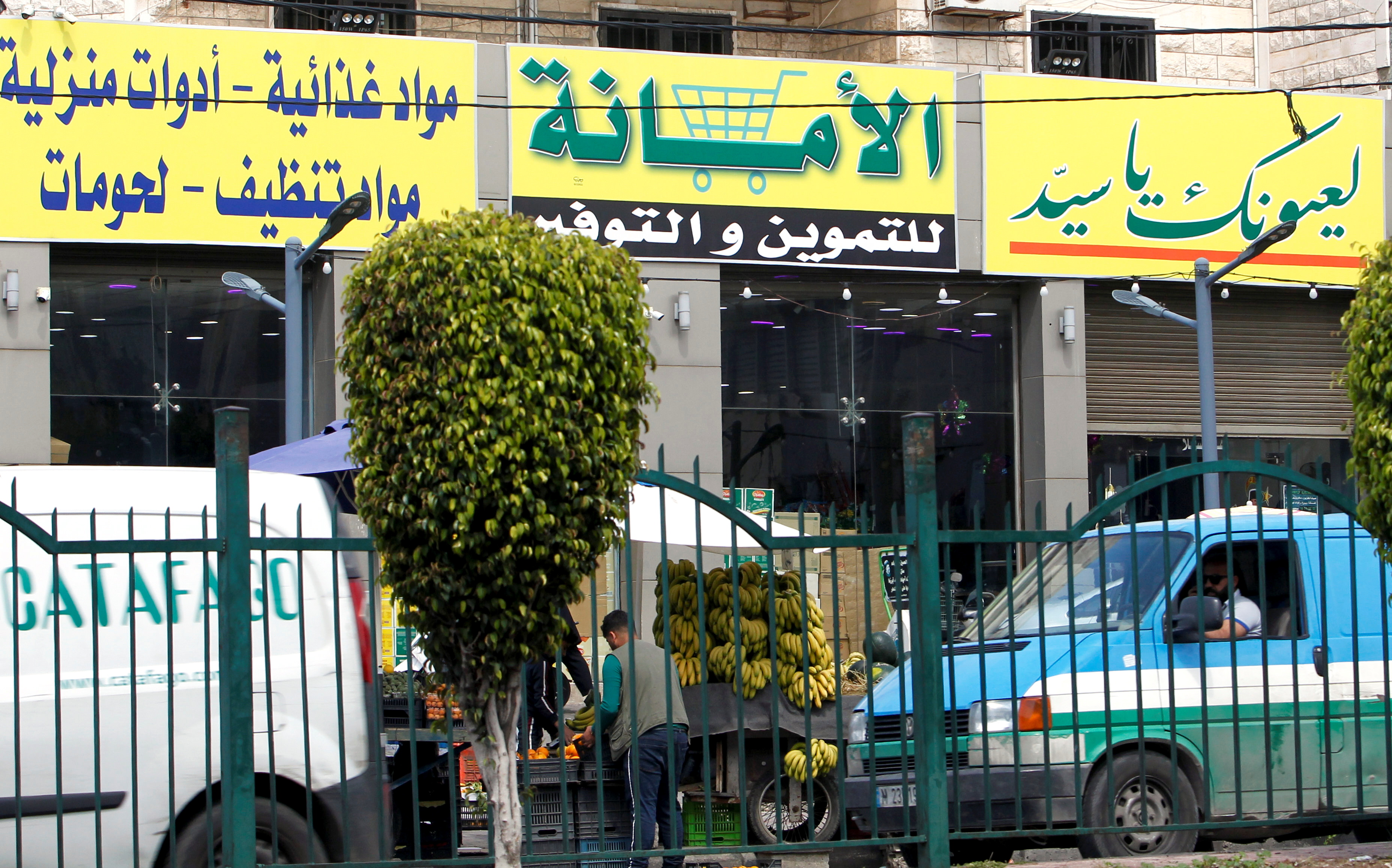 View shows a market for groceries with a Hezbollah slogan on it, in Beirut suburbs