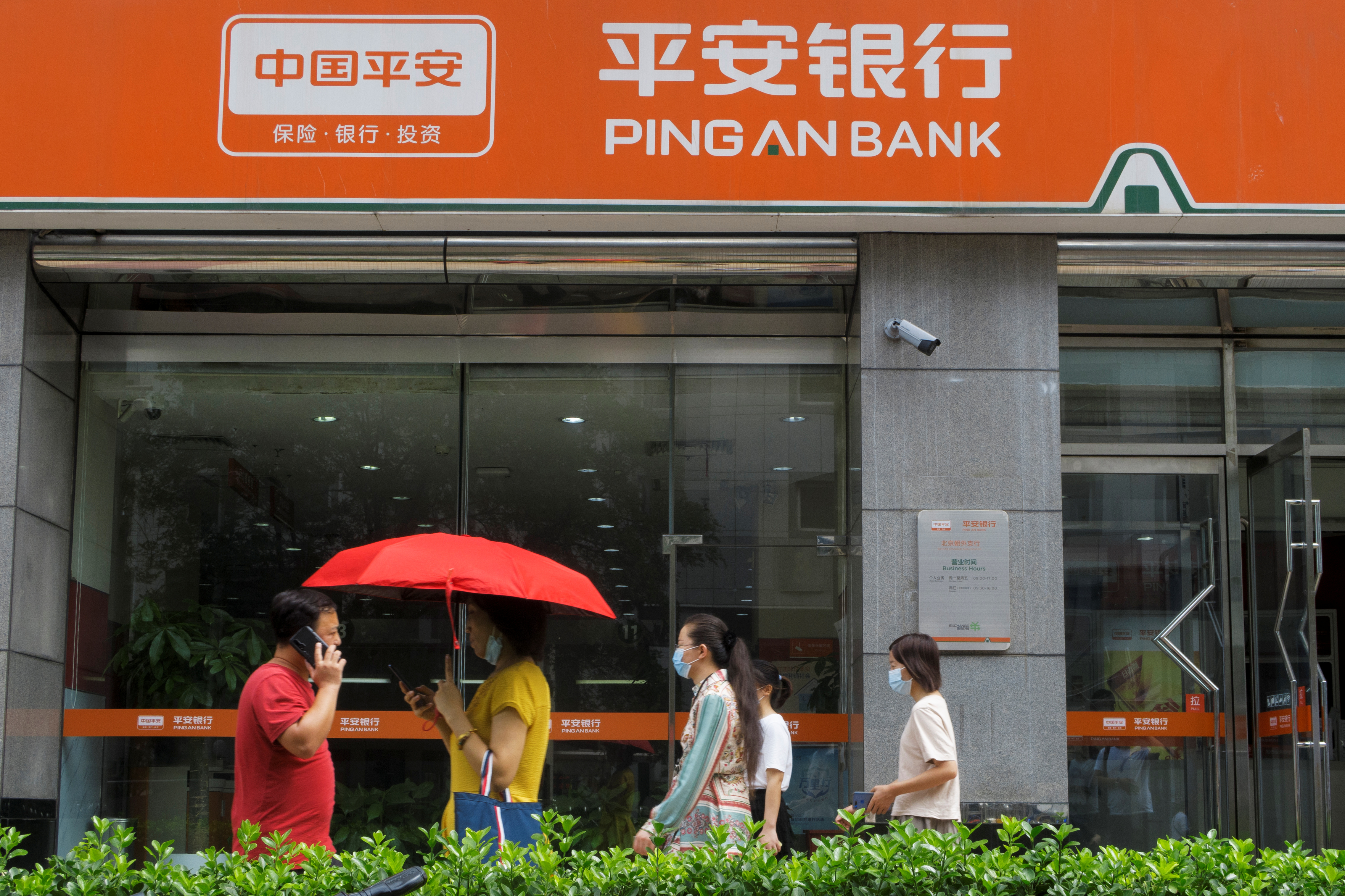 People walk past a branch of Ping An Bank, a subsidiary of Ping An Insurance, in Beijing