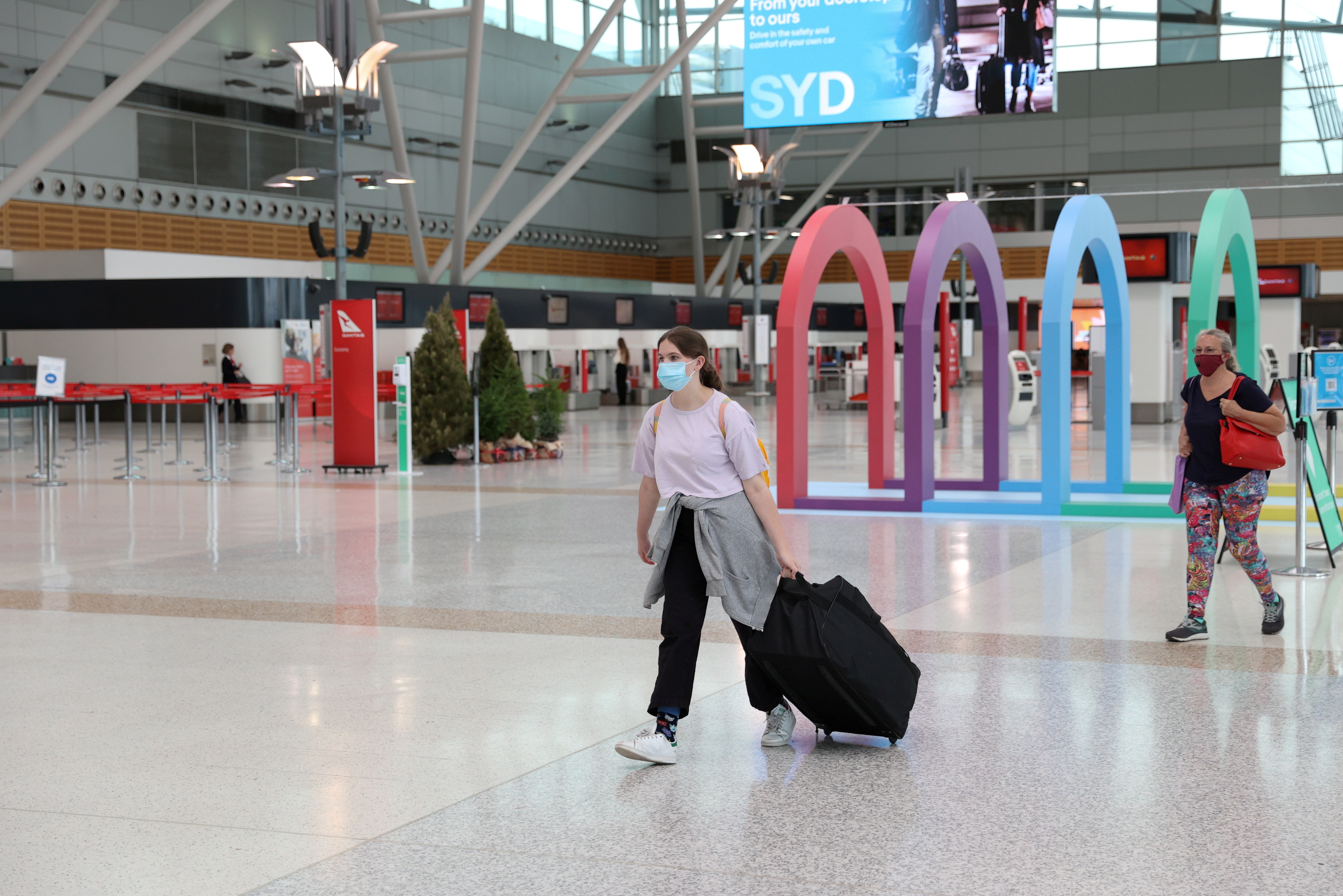 People walk through the domestic terminal at Sydney Airport in Sydney, Australia