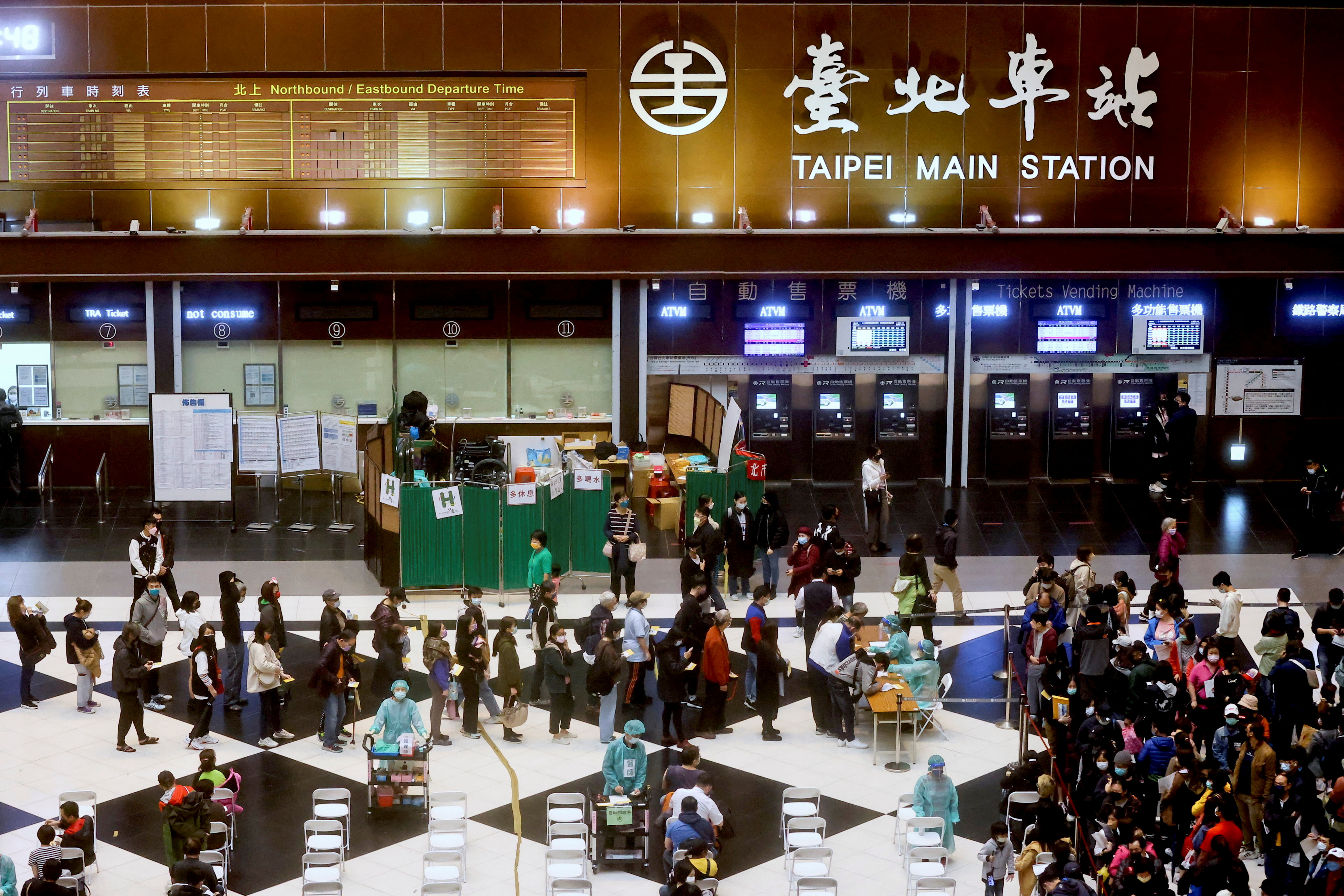 People wait to receive their booster shot of the coronavirus disease (COVID-19) vaccine at the lobby of Taipei main station ahead of Lunar new year in Taipei