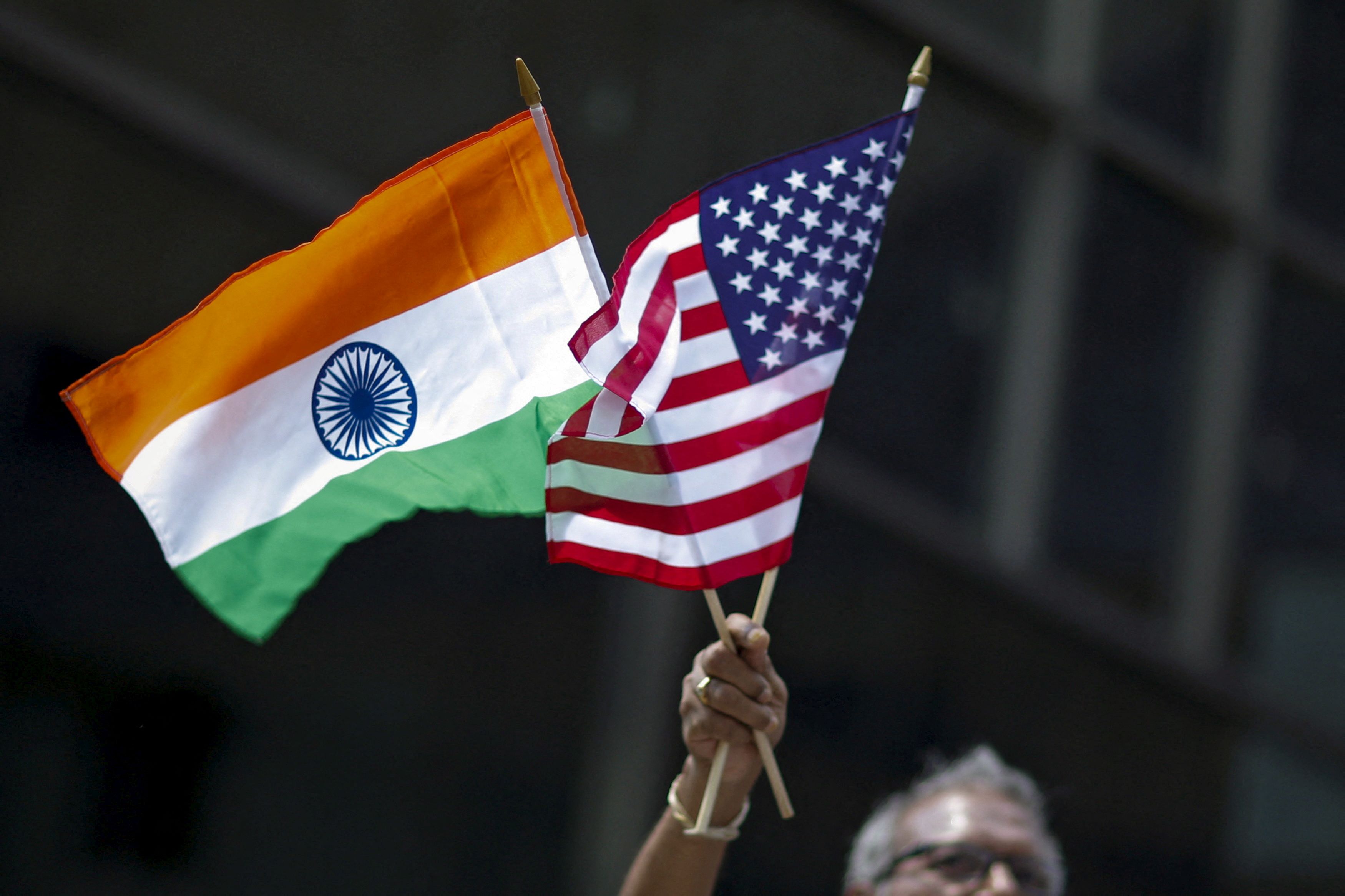 Man holds the flags while people take part in the 35th India Day Parade in New York