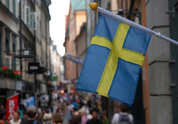 A Swedish flag hangs outside a store in the old town of Stockholm