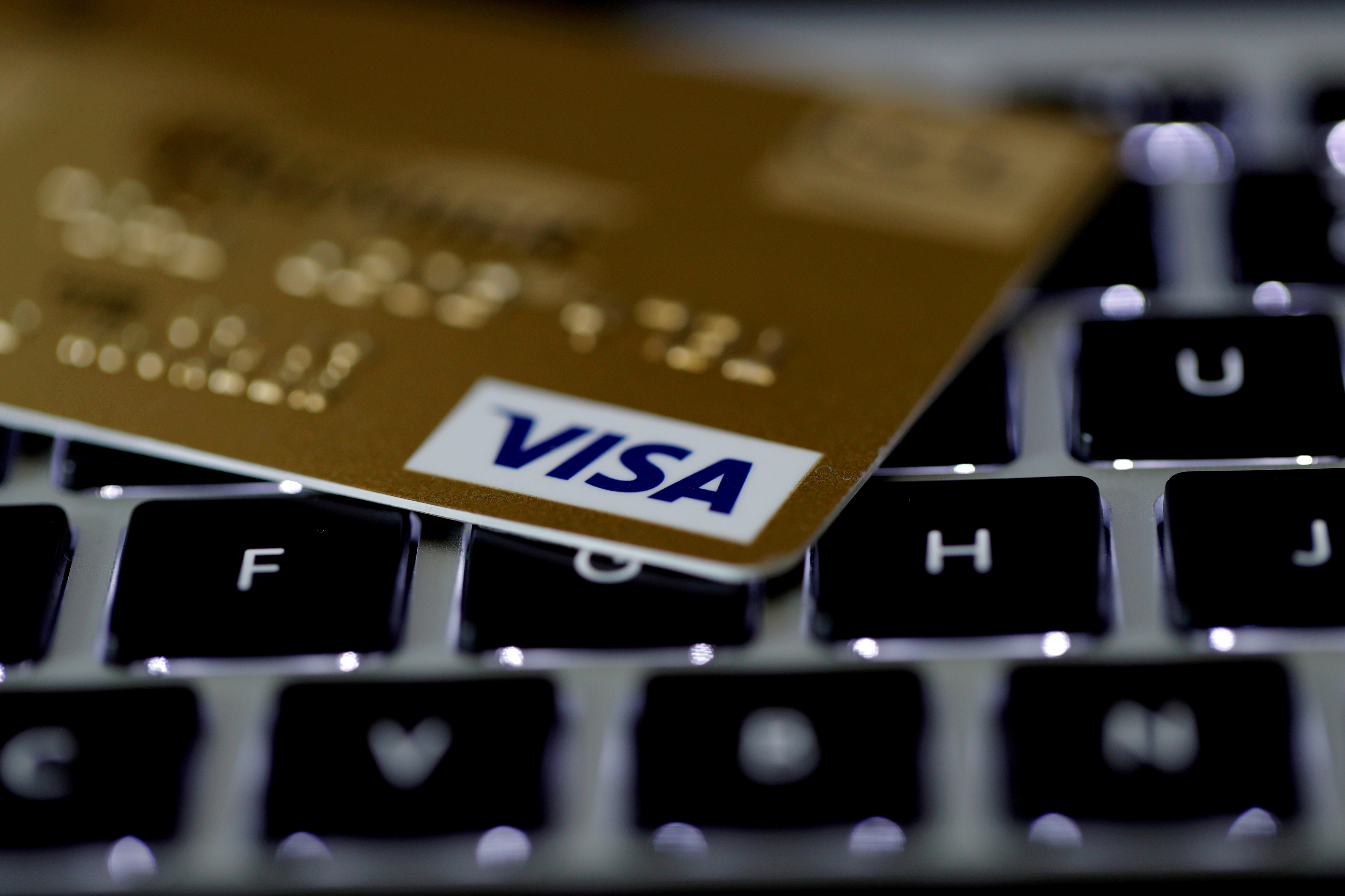 A Visa credit card is seen on a computer keyboard in this picture illustration