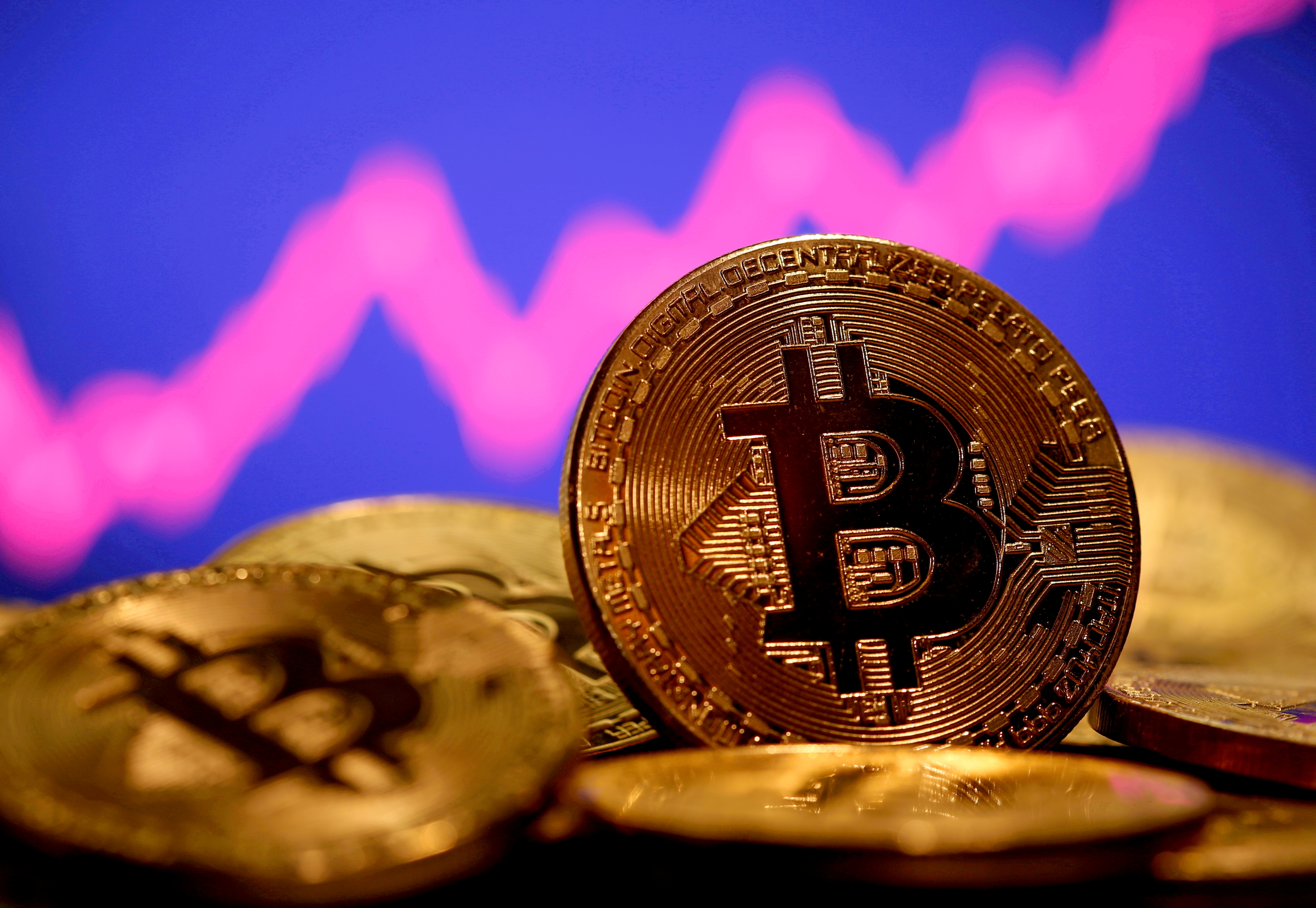 A representation of virtual currency Bitcoin is seen in front of a stock graph in this illustration taken January 8, 2021. REUTERS/Dado Ruvic/File Photo/File Photo