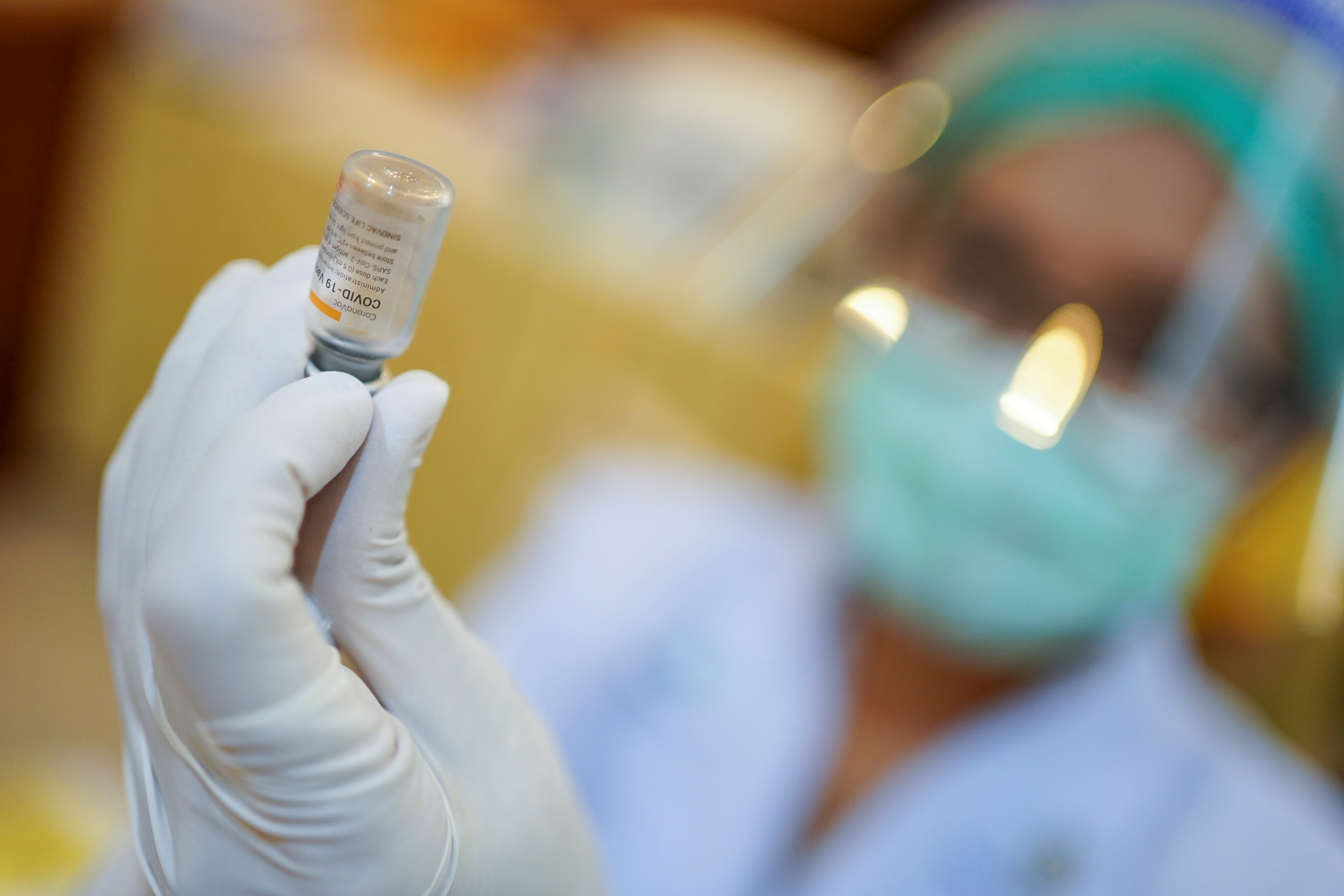 A health worker holds up a vial of Sinovac's CoronaVac coronavirus disease (COVID-19) vaccine at the Samut Sakhon hospital