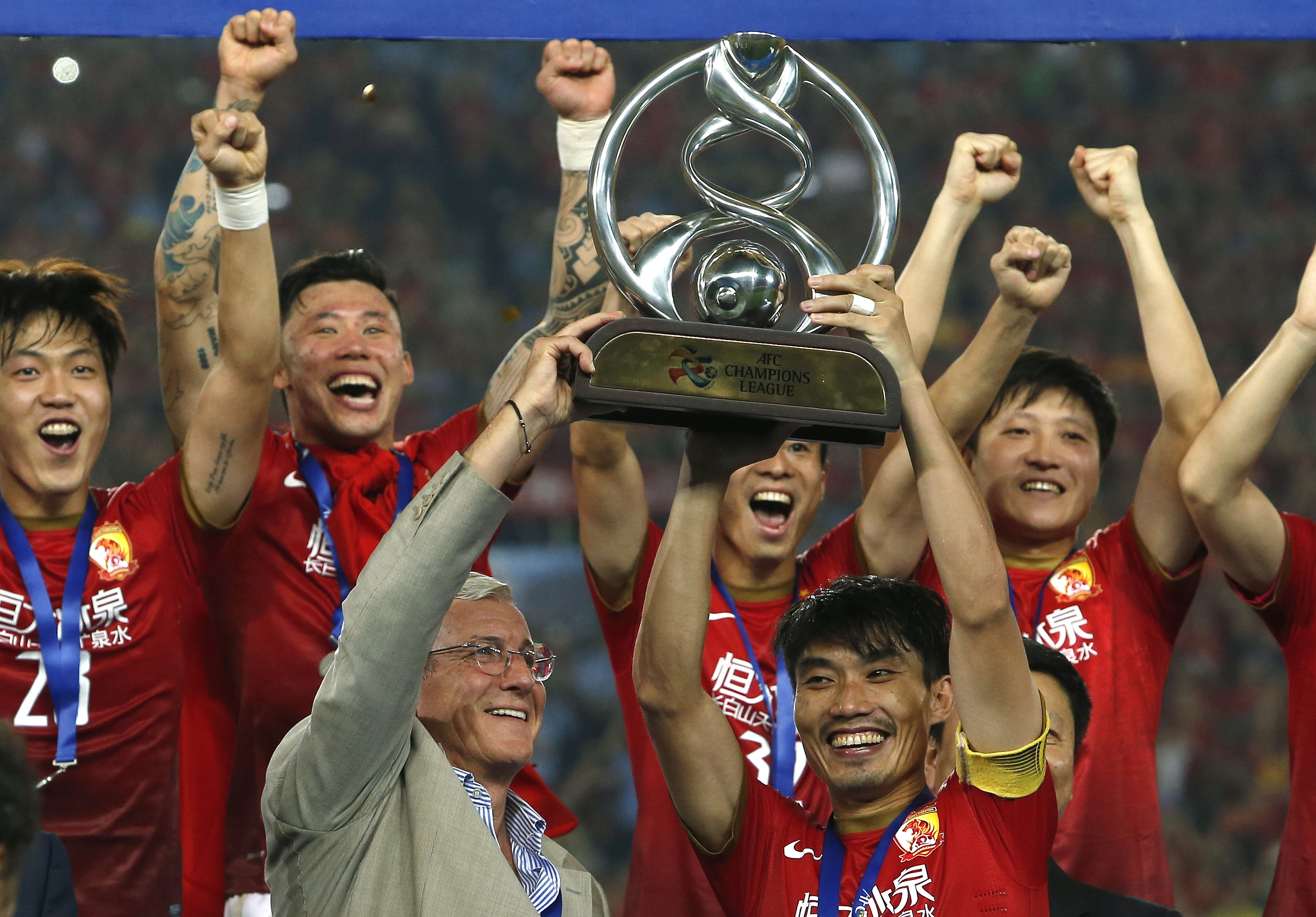 China's Guangzhou Evergrande coach Marcello Lippi and Zheng Zhi hold up the trophy after winning their final match of the AFC Champions' League against South Korea's FC Seoul in Guangzhou
