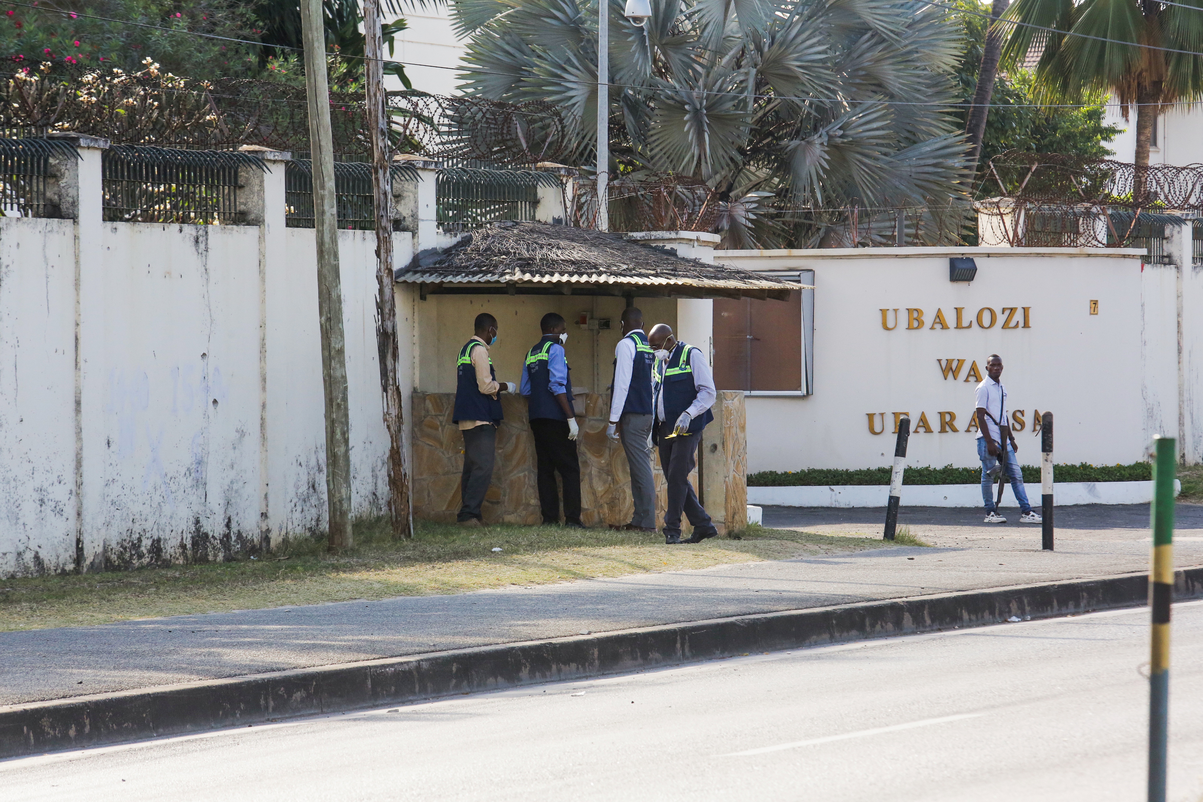 Tanzanian security officers guard an entrance to the French embassy after an attacker wielding an assault rifle was killed in the Salenda area of Dar es Salaam