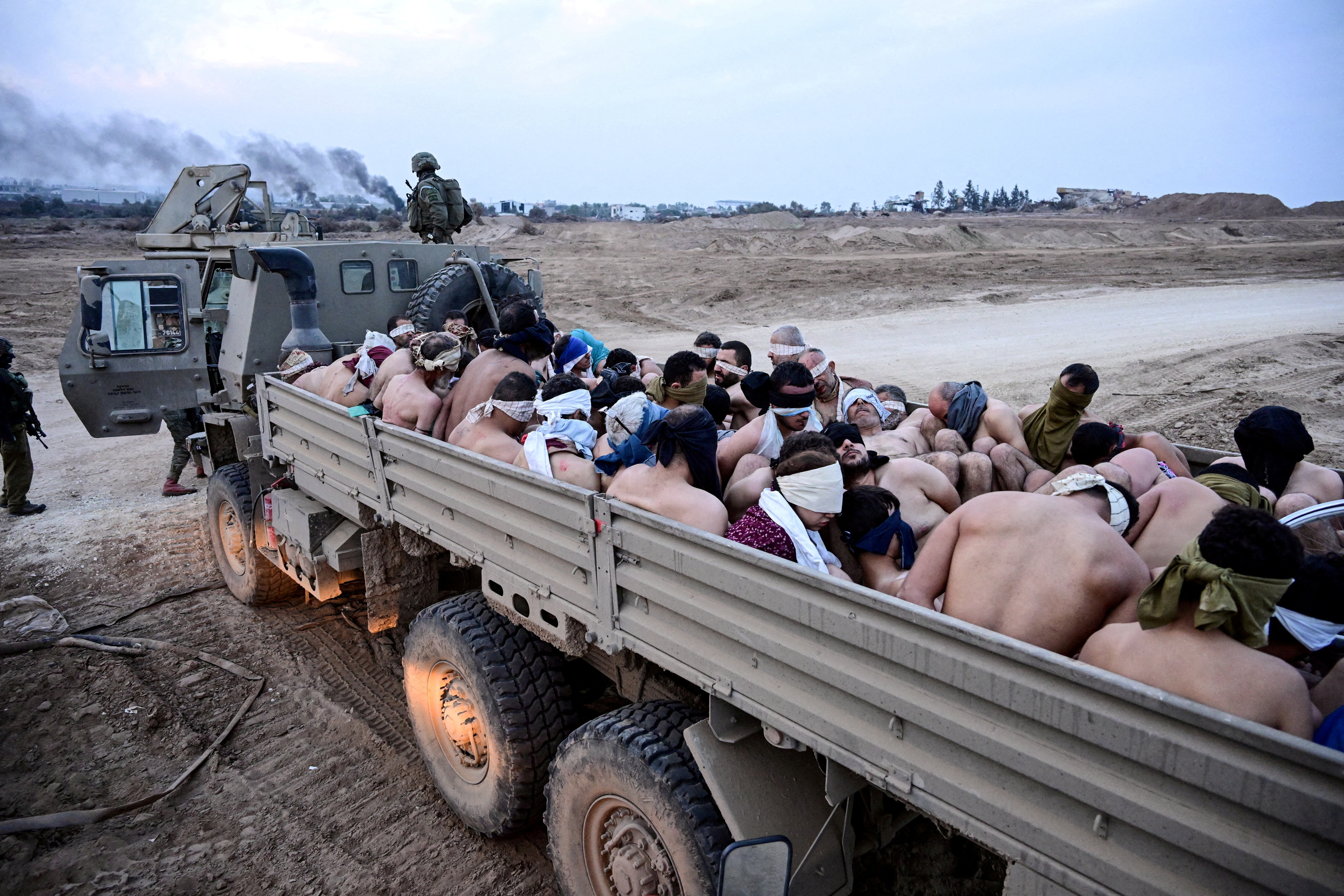 Israeli soldiers stand by truck with Palestinian detainees in the Gaza Strip