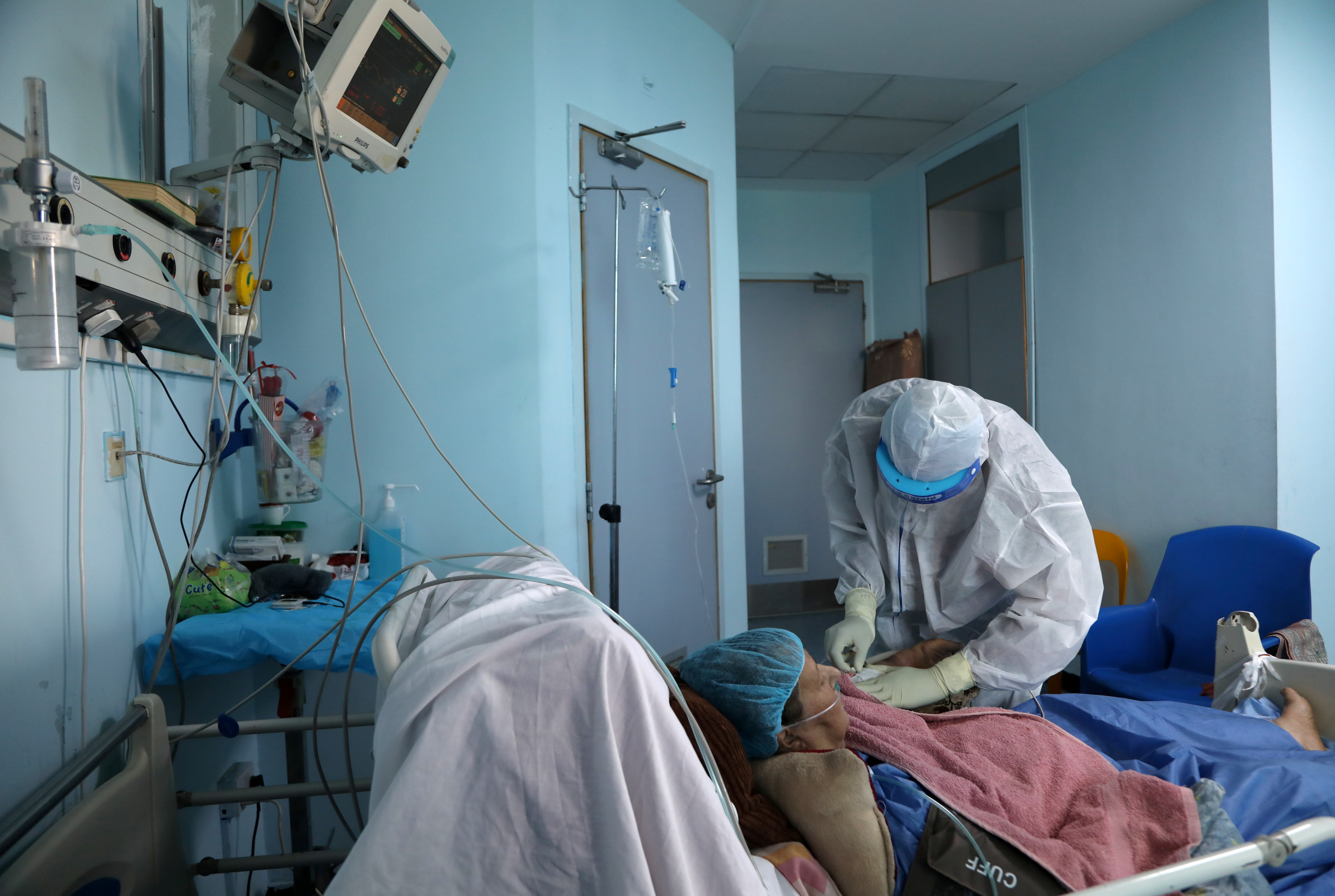 A nurse assists a patient suffering from coronavirus disease (COVID-19), in an intensive care unit inside a hospital in Amman, Jordan June 1, 2021. Picture taken June 1, 2021. REUTERS/Alaa Al Sukhni