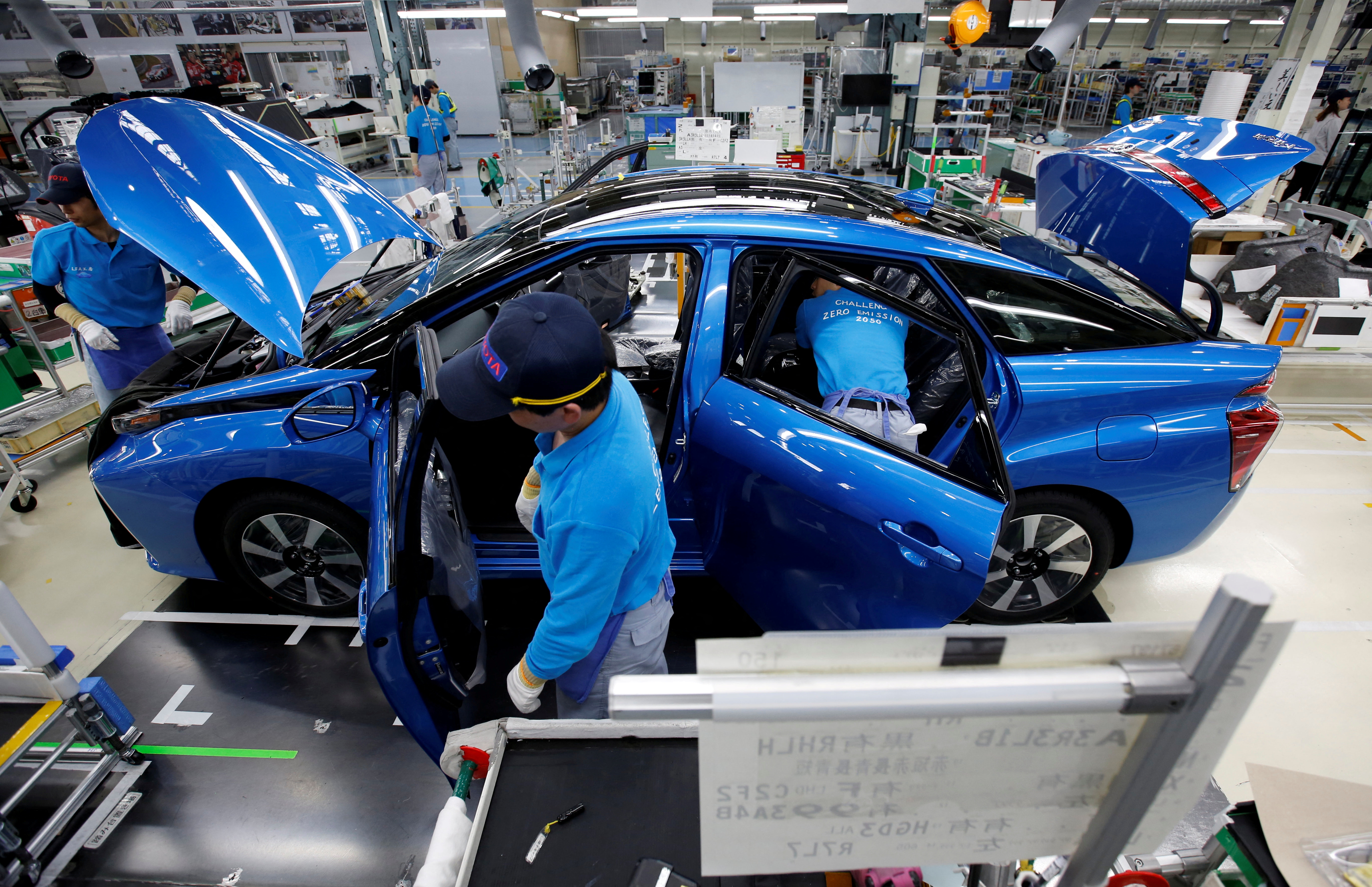 Employees of Toyota Motor Corp. work on an assembly line
