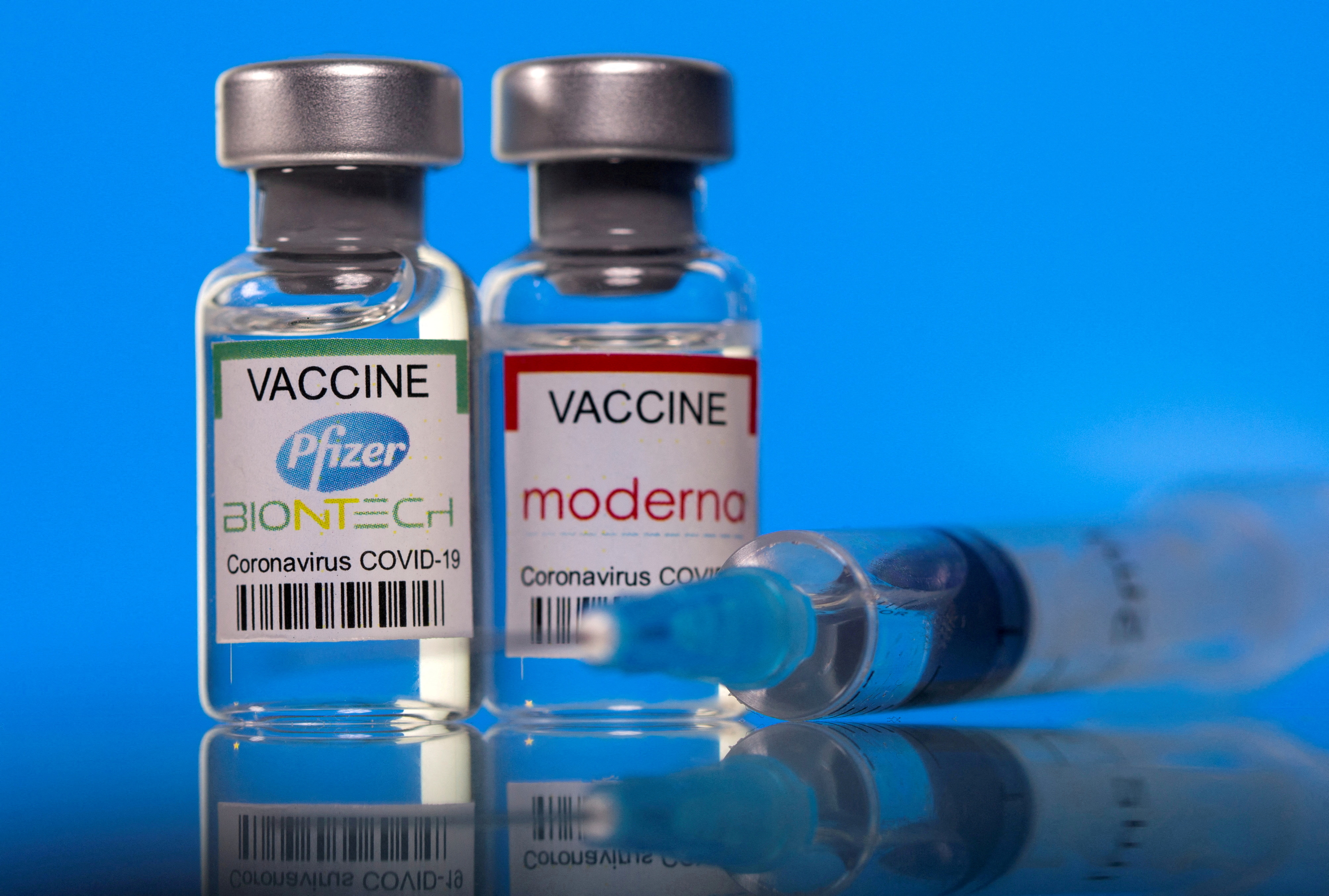 Vials with Pfizer-BioNTech and Moderna coronavirus disease (COVID-19) vaccine labels are seen in this illustration picture taken March 19, 2021. REUTERS/Dado Ruvic/Illustration