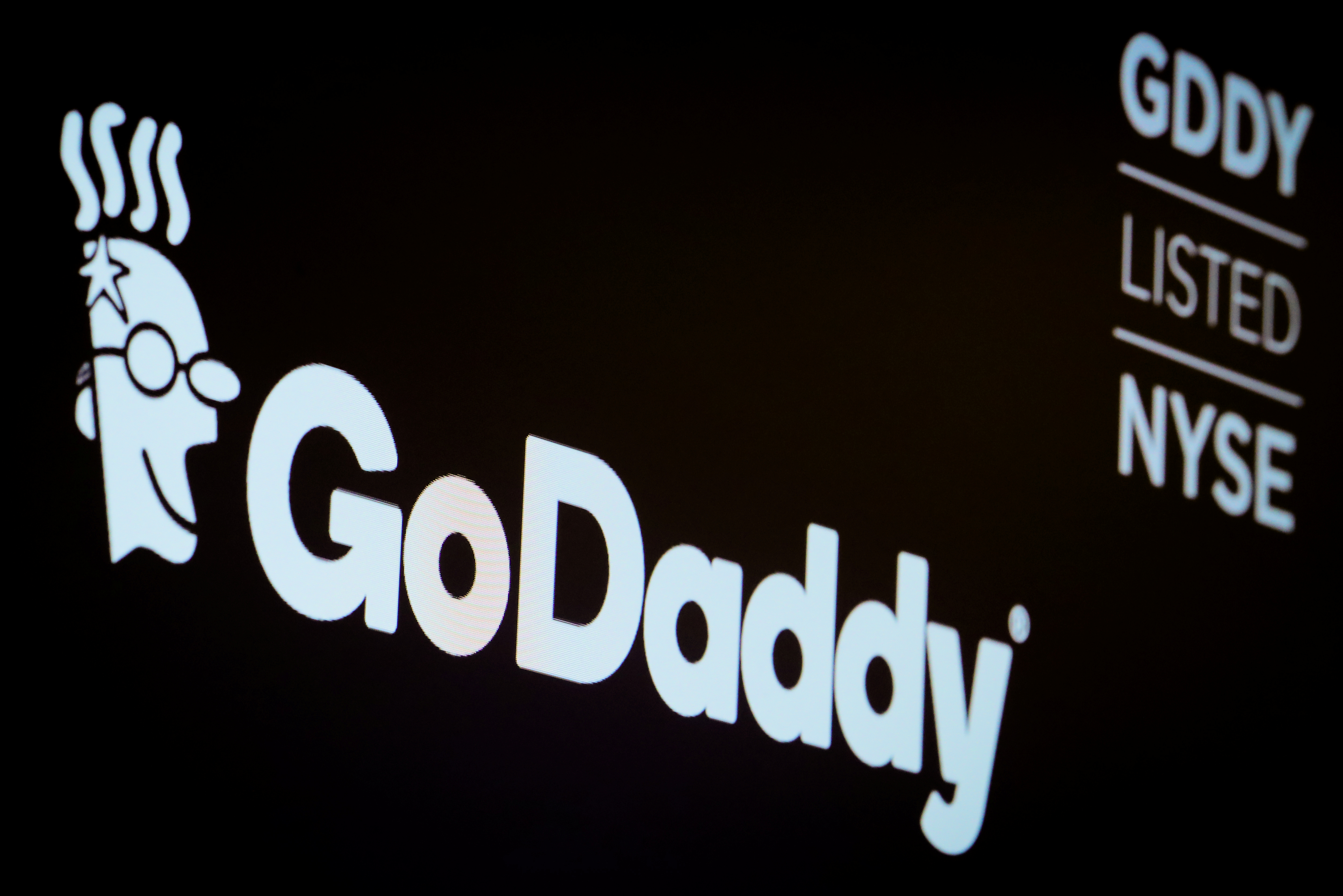 The company logo and ticker for GoDaddy Inc. is displayed on a screen on the floor of the NYSE in New York
